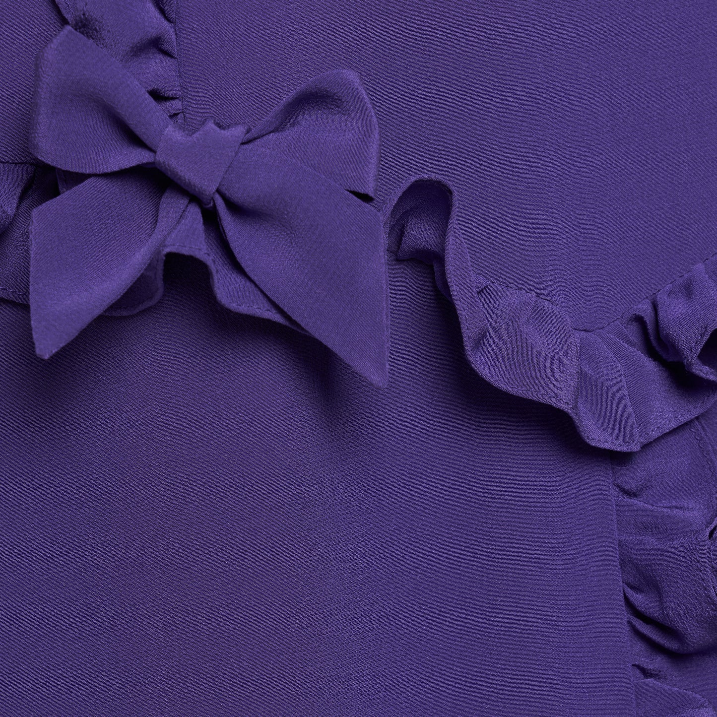 Purple silk crêpe de chine dress with a wide collar, ruffle details, bows and a centre split.

Look 7 – Fall Winter 2026 Lookbook.