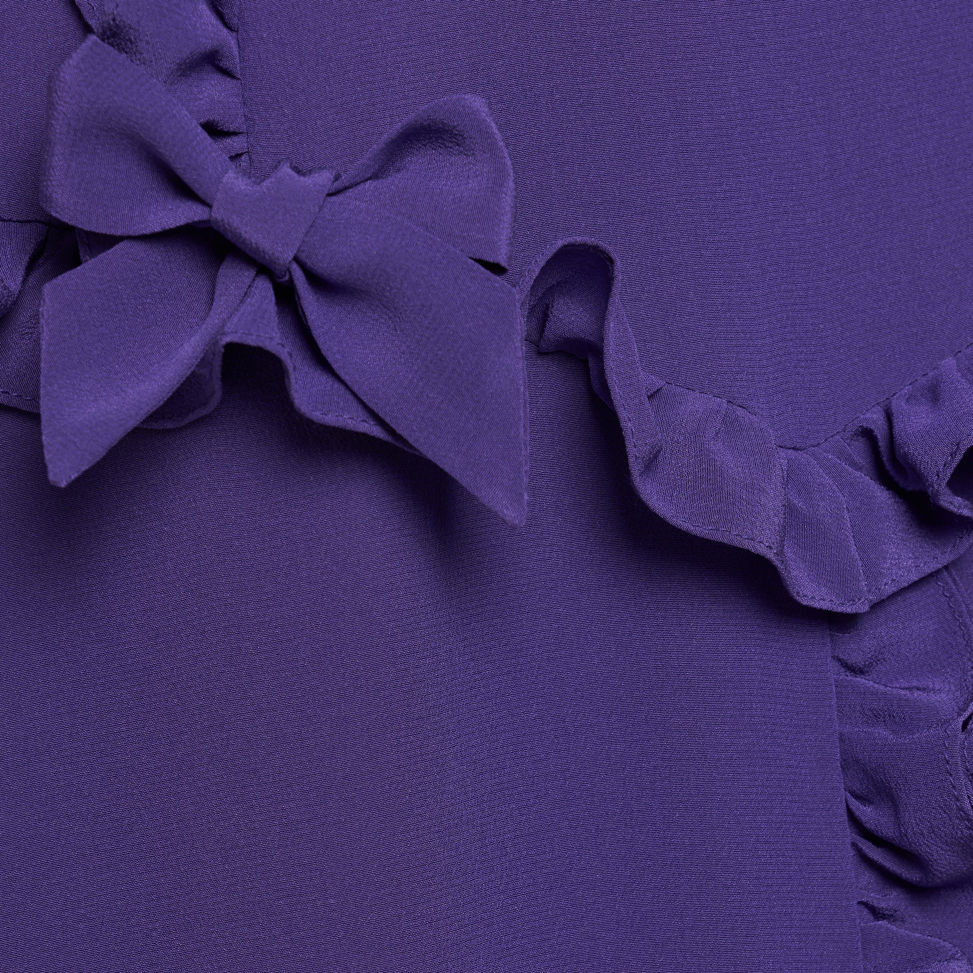 Purple silk crêpe de chine dress with a wide collar, ruffle details, bows and a centre split.

Look 7 – Fall Winter 2026 Lookbook.