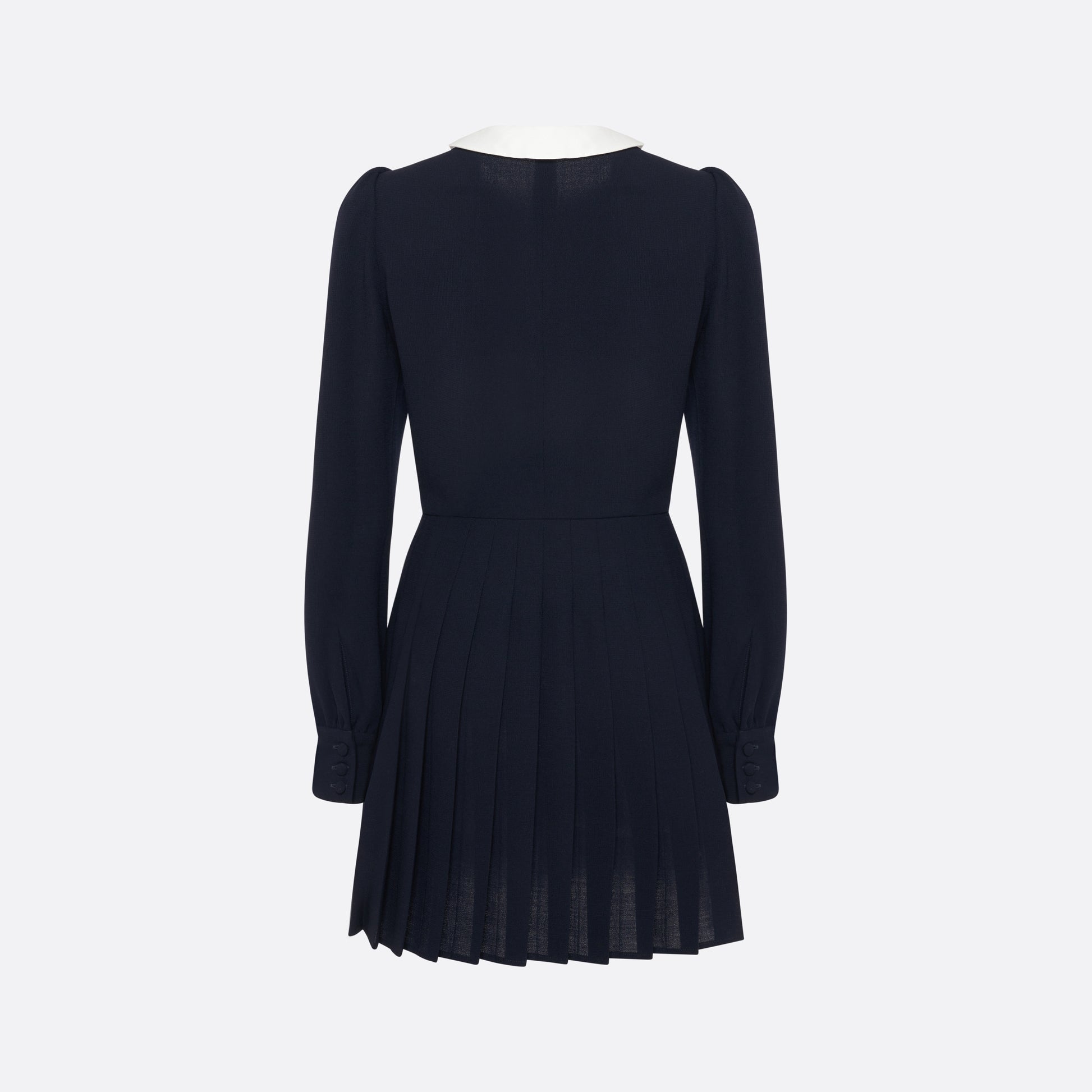 Navy blue light wool crêpe mini dress with a front button closure with black and gold tone buttons and a pleated skirt. Finished with a contrast collar and ruffle details.