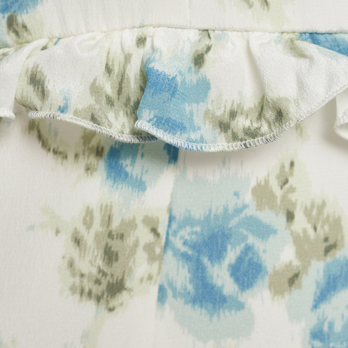 Light blue and white floral-print silk crêpe de chine mini dress with bow-detailed shoulder straps and a ruffled neckline. The silhouette is defined by ruffles at the waist and hem.