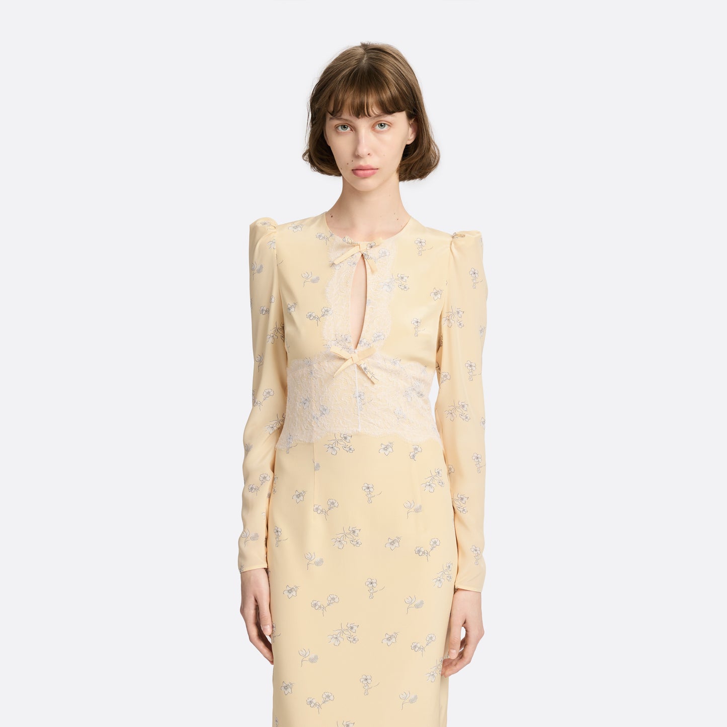 Pale yellow floral print silk crêpe de chine midi dress with long sleeves, featuring keyhole cut-out, lace inlay and bows.