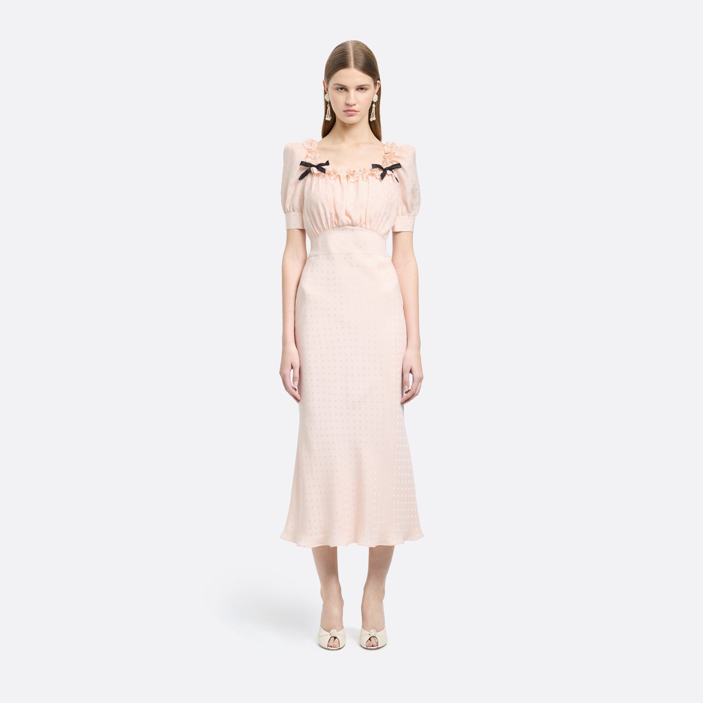 Light pink star-jacquard silk midi dress with short puff sleeves and a square neckline detailed with black bows and a ruffled trim.