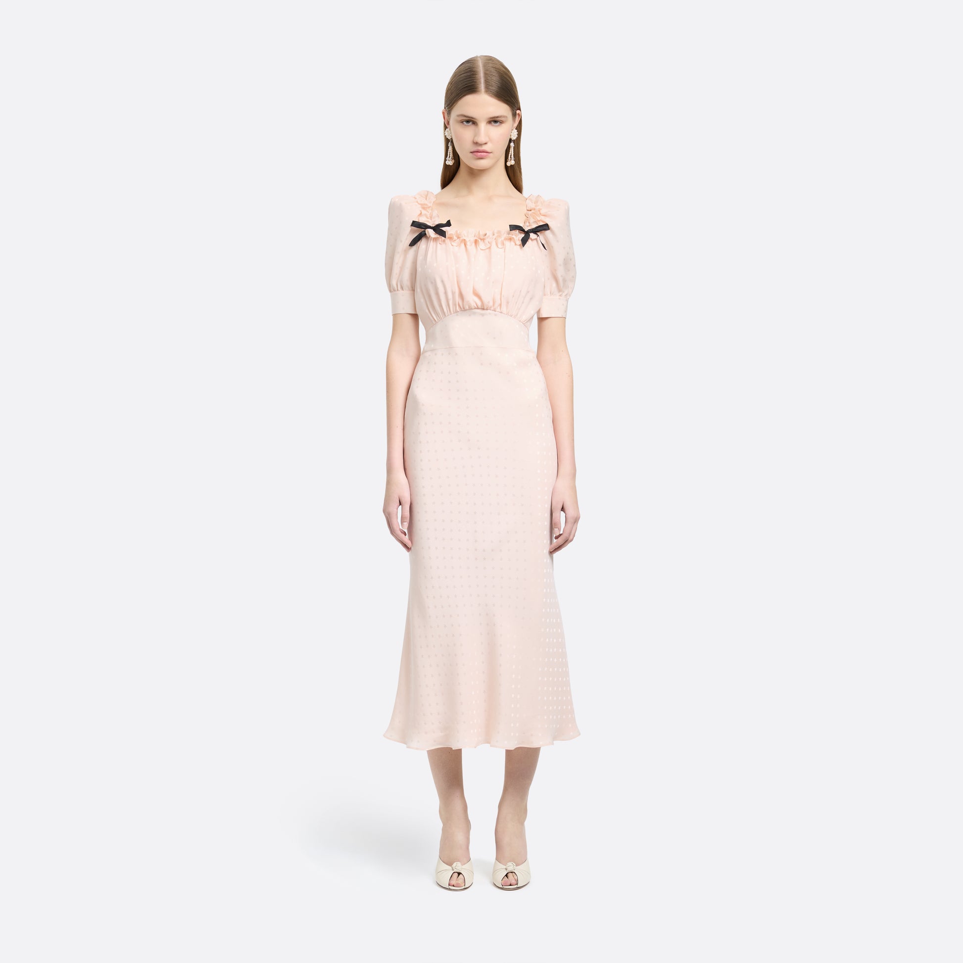 Light pink star-jacquard silk midi dress with short puff sleeves and a square neckline detailed with black bows and a ruffled trim.