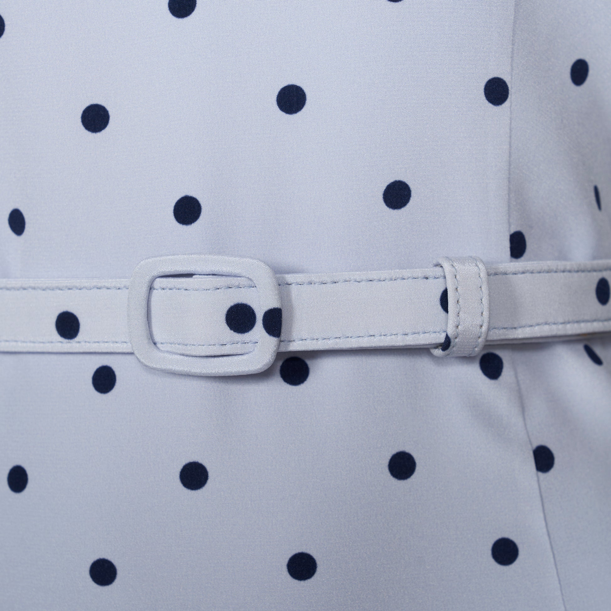 Light blue polka-dot silk crêpe de chine halterneck dress with a bow detail at the neckline. Defined by a fitted waist with a slim belt, the silhouette is finished with a flared skirt.