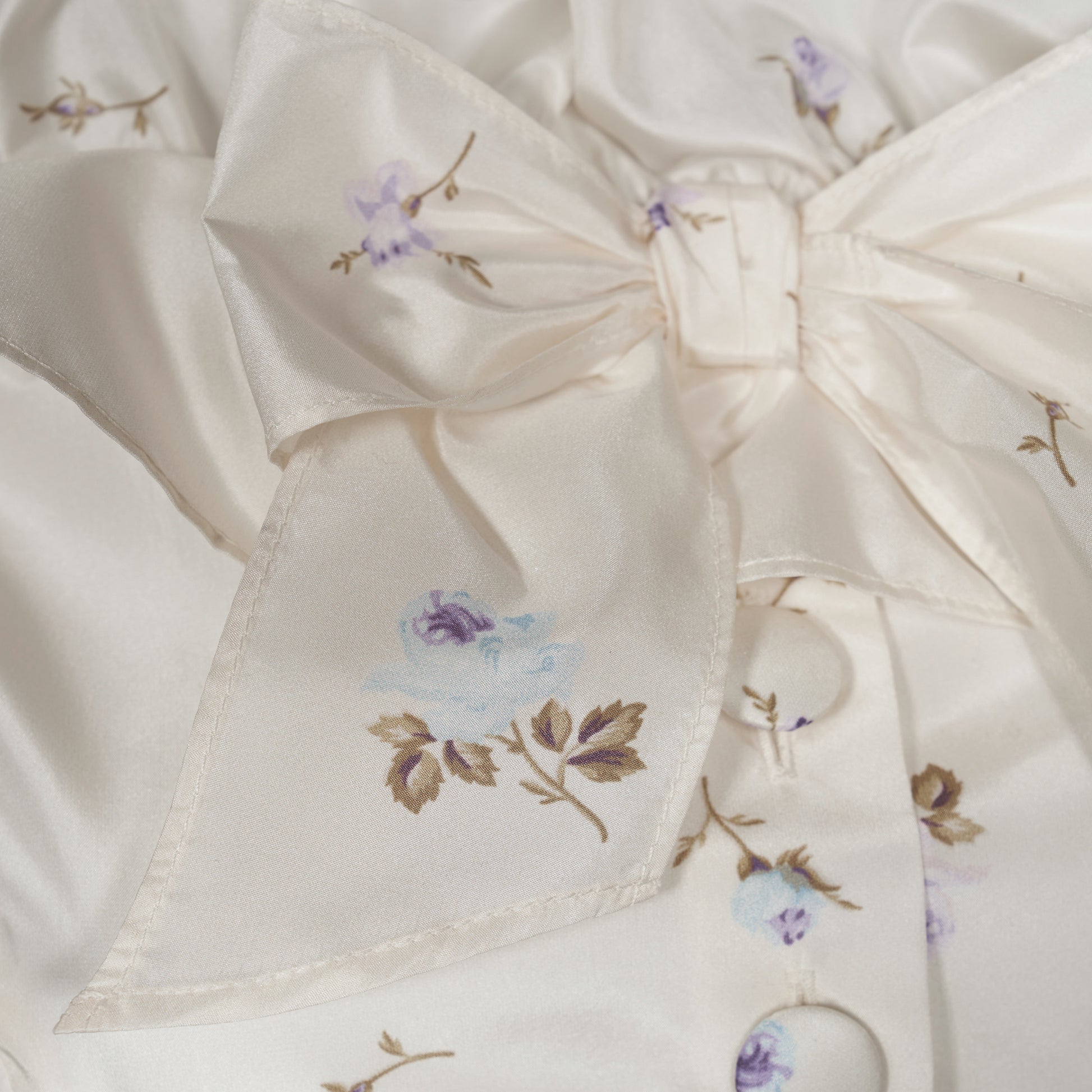Floral-print white silk taffeta off-shoulder midi dress cut to a fitted silhouette and detailed with a ruffled neckline and bow. Finished with a peplum frill and a slim belt.

Look 11 – Fall Winter 2026 Lookbook.