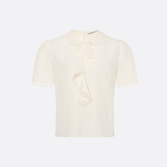 Cream silk crêpe de chine blouse with small collar, jabot and short sleeves all trimmed in lace and a back button closure.