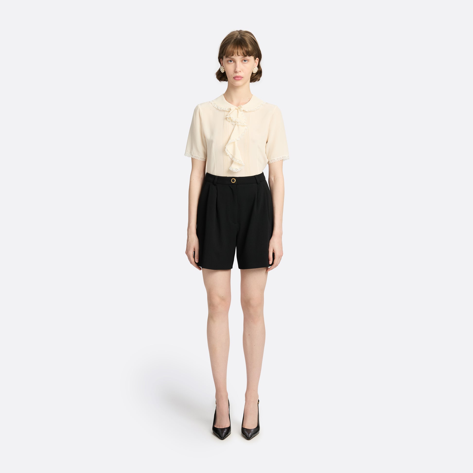 Cream silk crêpe de chine blouse with small collar, jabot and short sleeves all trimmed in lace and a back button closure.