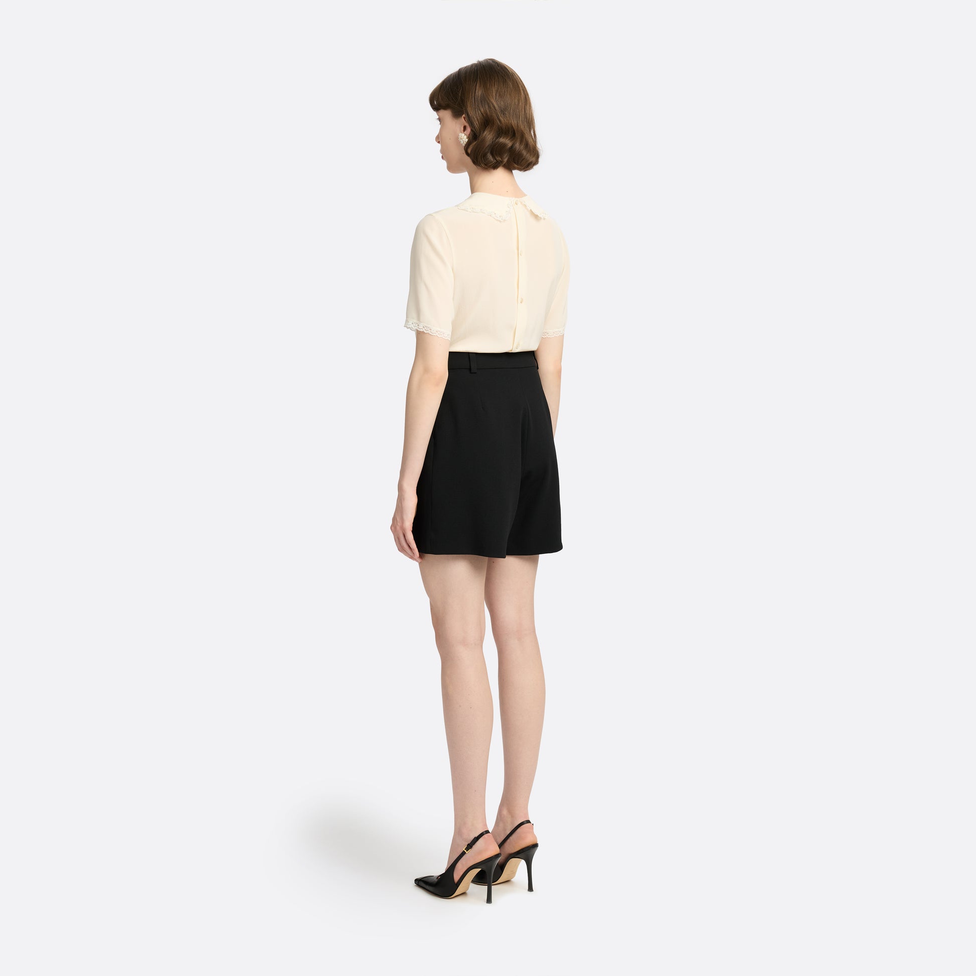Cream silk crêpe de chine blouse with small collar, jabot and short sleeves all trimmed in lace and a back button closure.