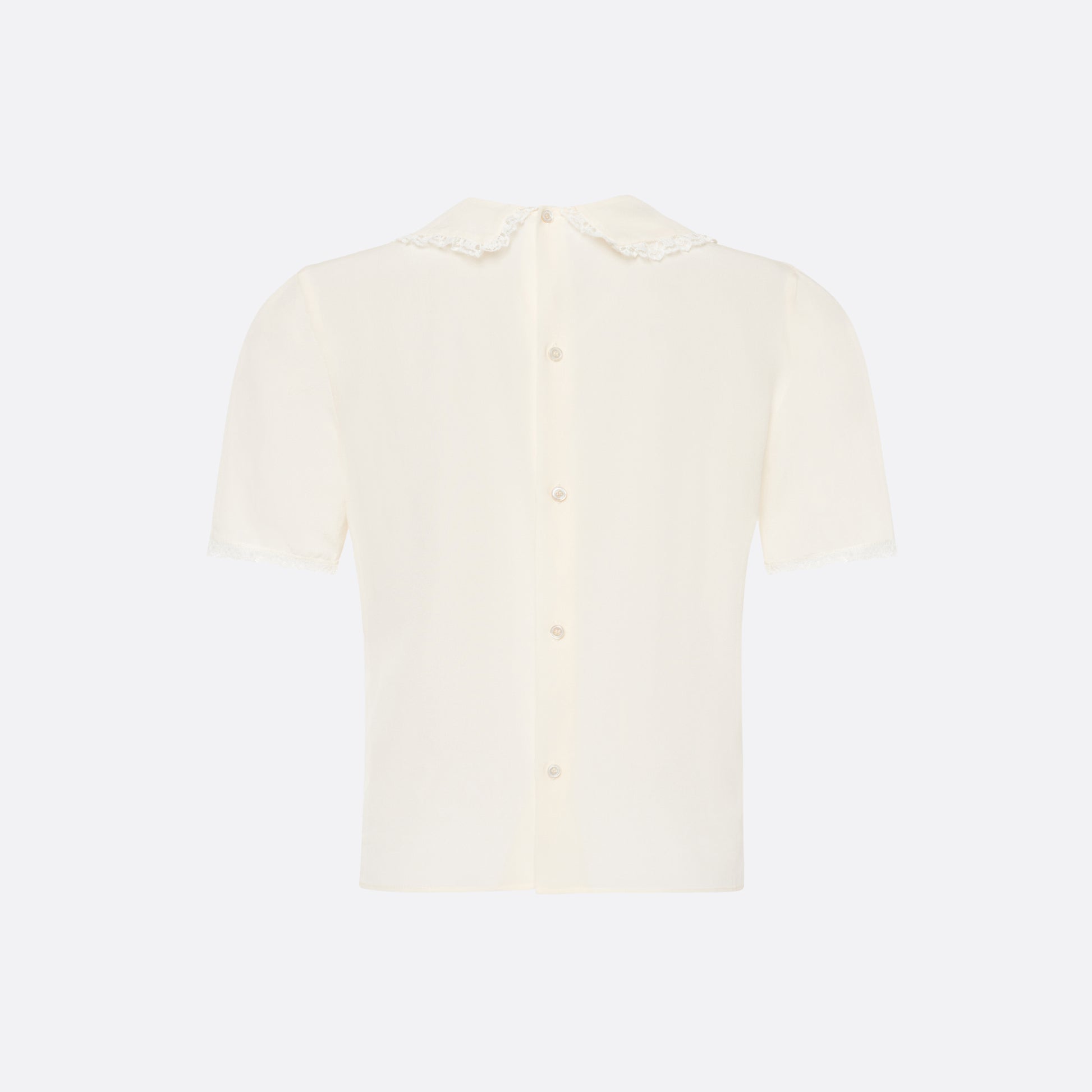 Cream silk crêpe de chine blouse with small collar, jabot and short sleeves all trimmed in lace and a back button closure.