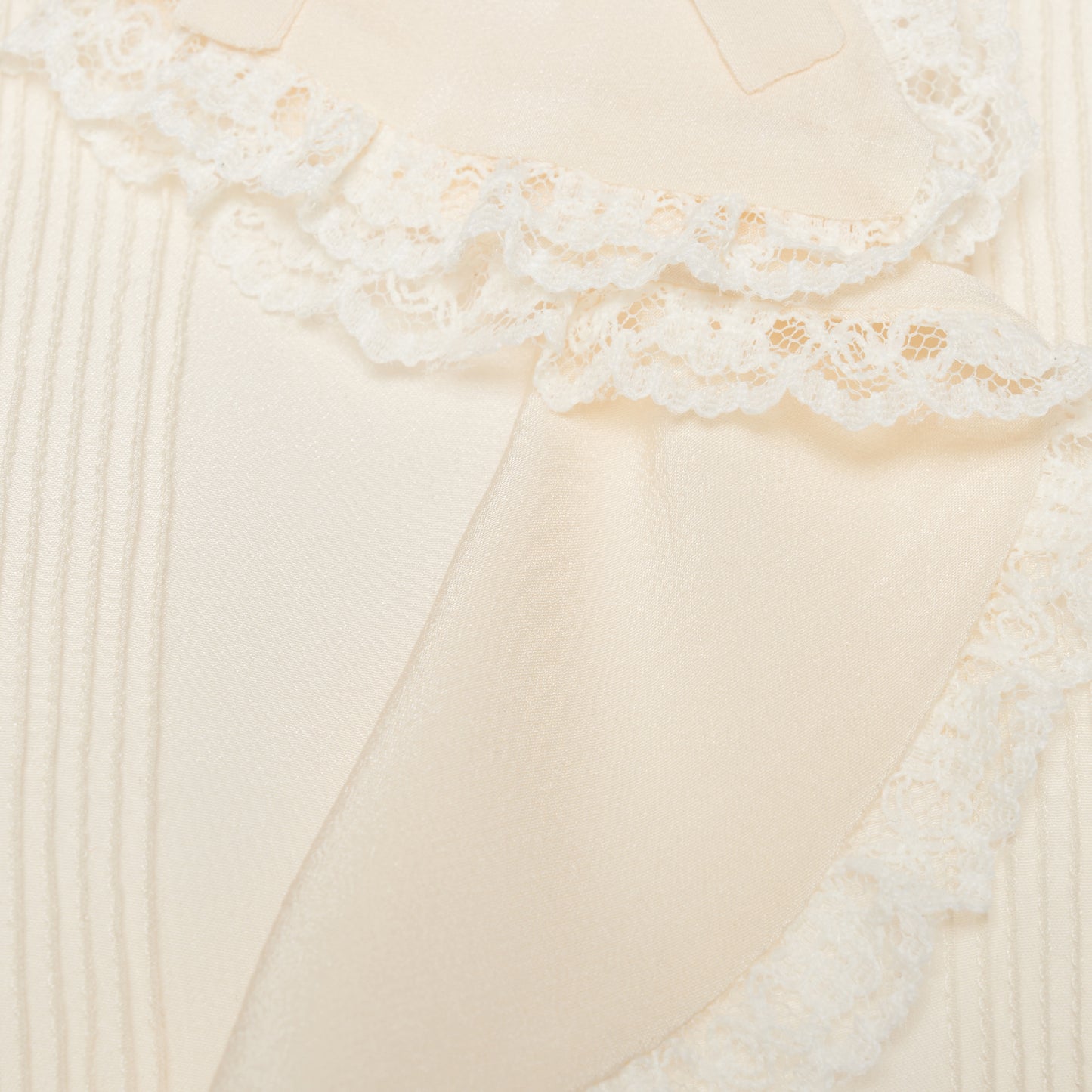Cream silk crêpe de chine blouse with small collar, jabot and short sleeves all trimmed in lace and a back button closure.