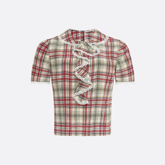Red and green tartan-print  silk crêpe de chine blouse with small collar, jabot and short sleeves all trimmed in white lace. The blouse is fastened with a back button closure.

Look 32 – Fall Winter 2026 Lookbook.