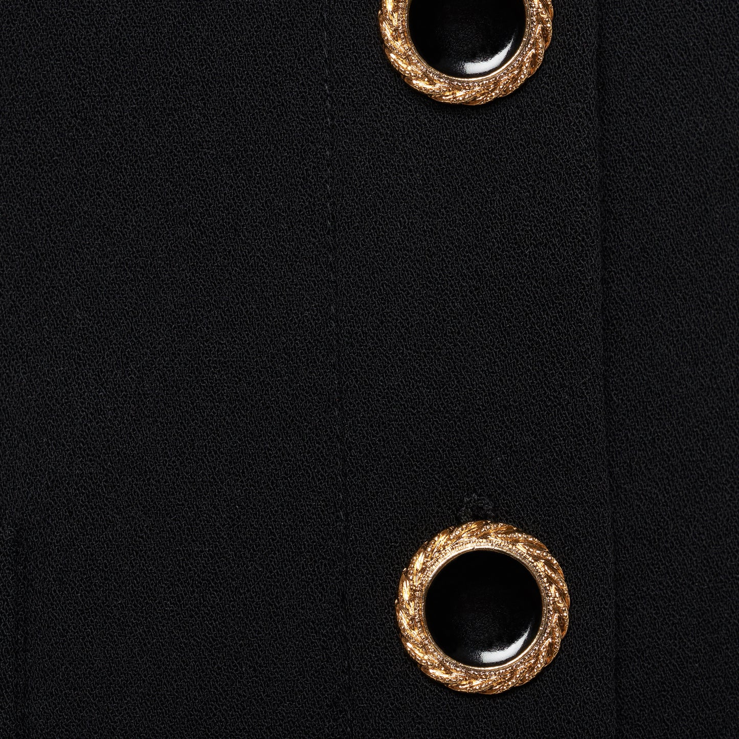 Black wool crêpe off-shoulder jacket with a wide folded neckline and short sleeves. Finished with black and gold-tone buttons and welt pockets.