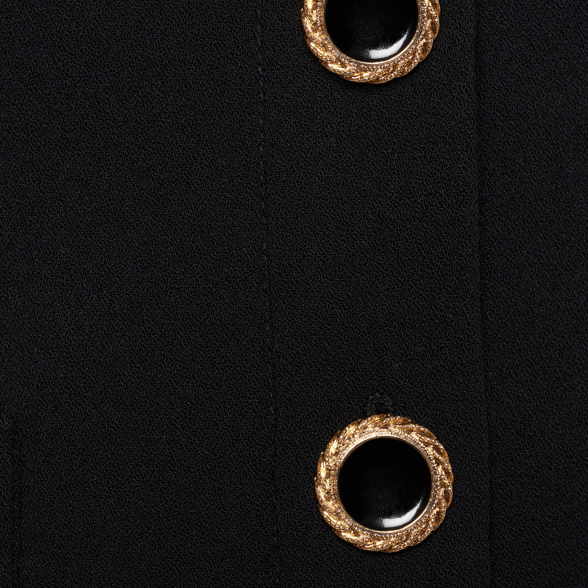 Black wool crêpe off-shoulder jacket with a wide folded neckline and short sleeves. Finished with black and gold-tone buttons and welt pockets.