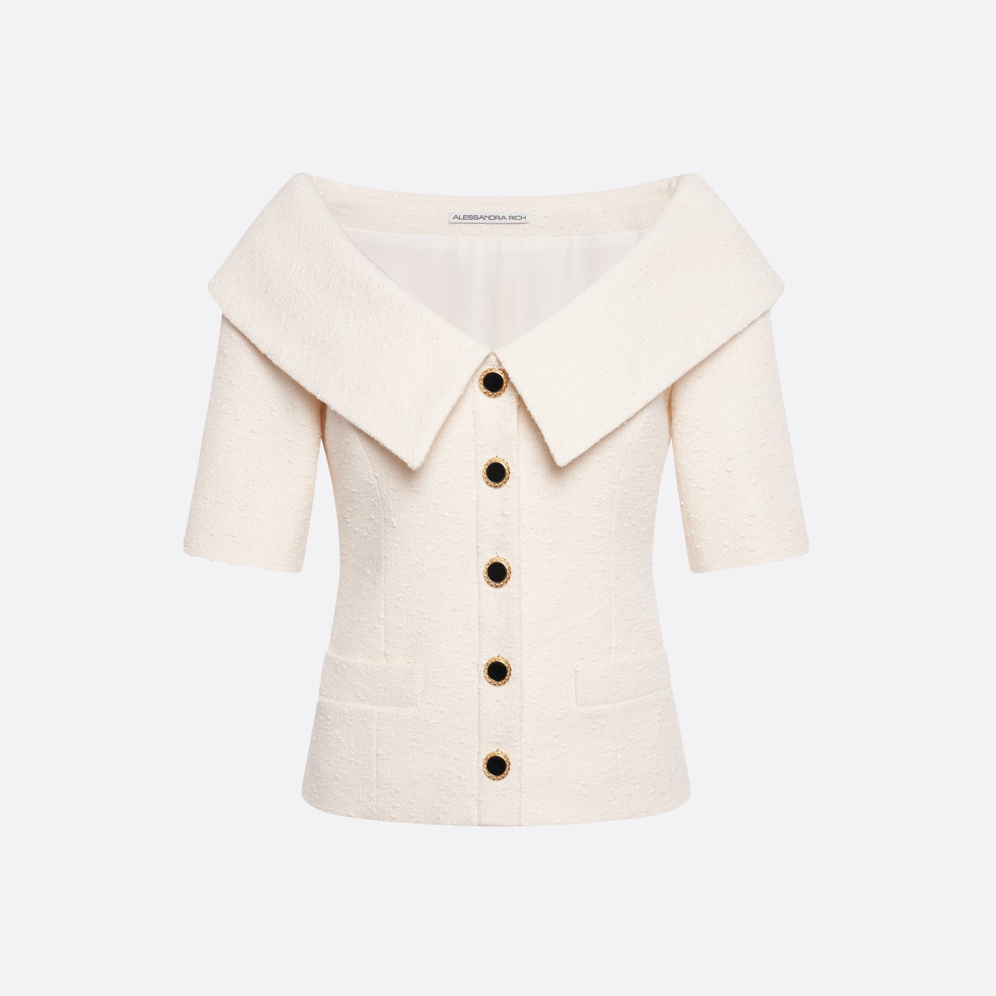 Ivory tweed bouclé off-shoulder jacket with a wide folded neckline and short sleeves. Finished with black and gold-tone buttons and welt pockets.