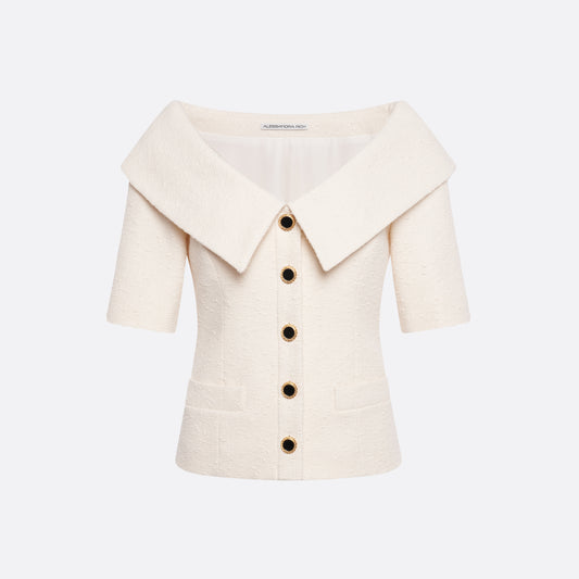 Ivory tweed bouclé off-shoulder jacket with a wide folded neckline and short sleeves. Finished with black and gold-tone buttons and welt pockets.