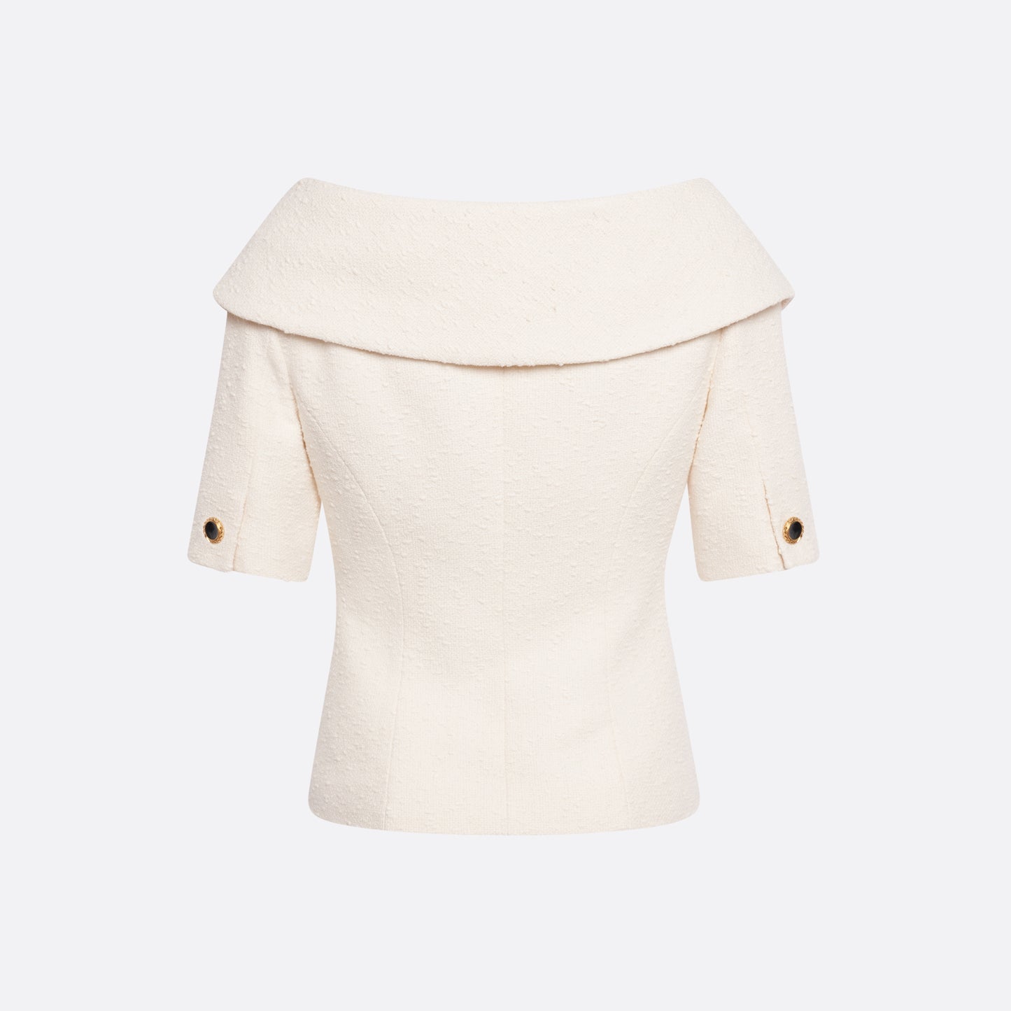 Ivory tweed bouclé off-shoulder jacket with a wide folded neckline and short sleeves. Finished with black and gold-tone buttons and welt pockets.