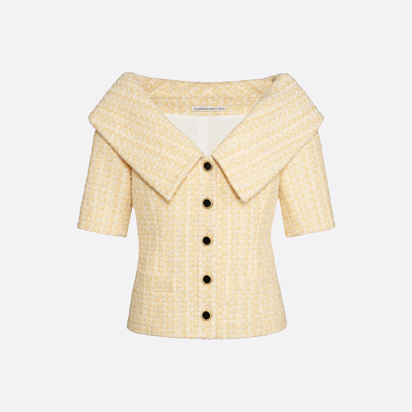 Pale yellow sequin tweed off-shoulder jacket with a wide folded neckline and short sleeves. Finished with black and gold-tone buttons and welt pockets.