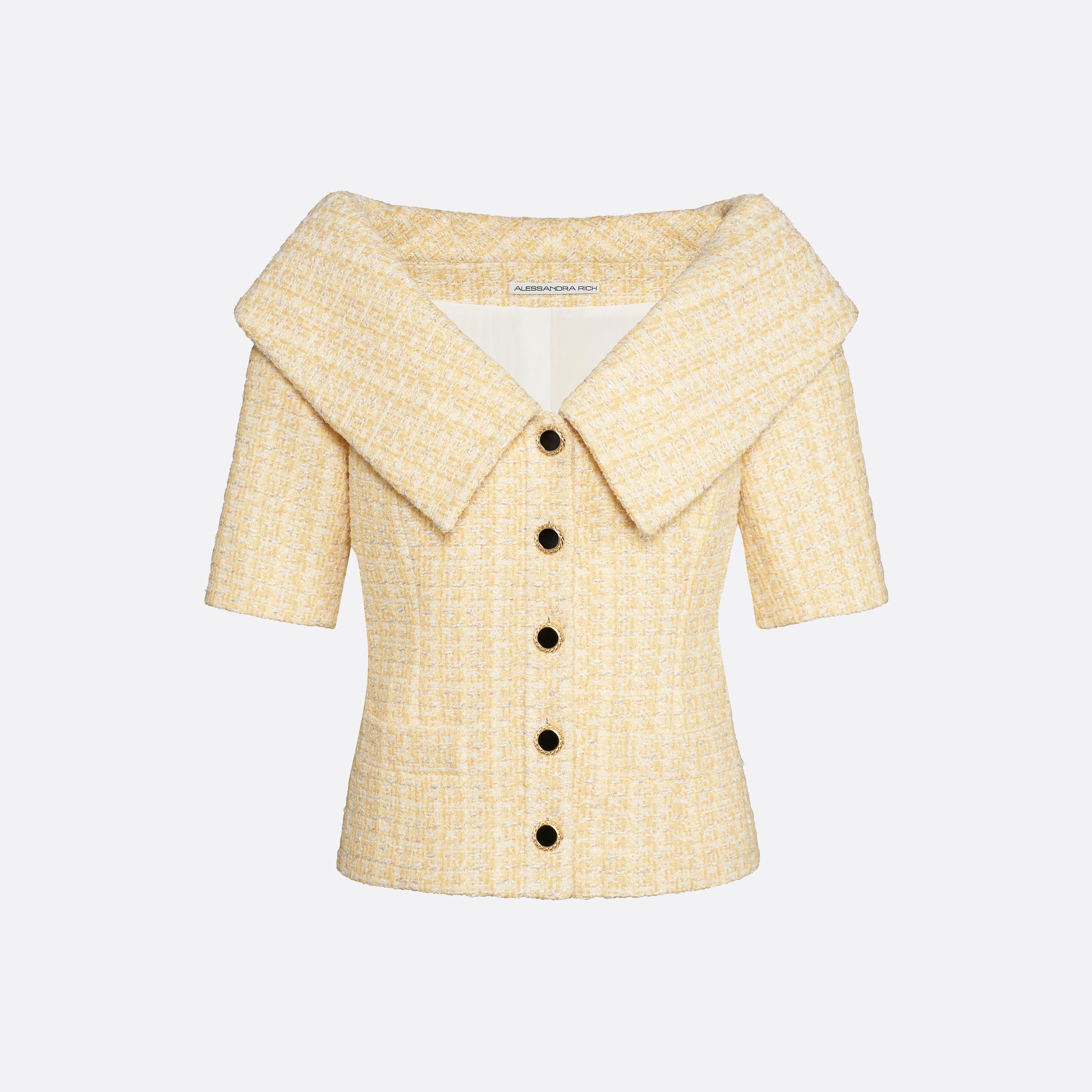 Pale yellow sequin tweed off-shoulder jacket with a wide folded neckline and short sleeves. Finished with black and gold-tone buttons and welt pockets.