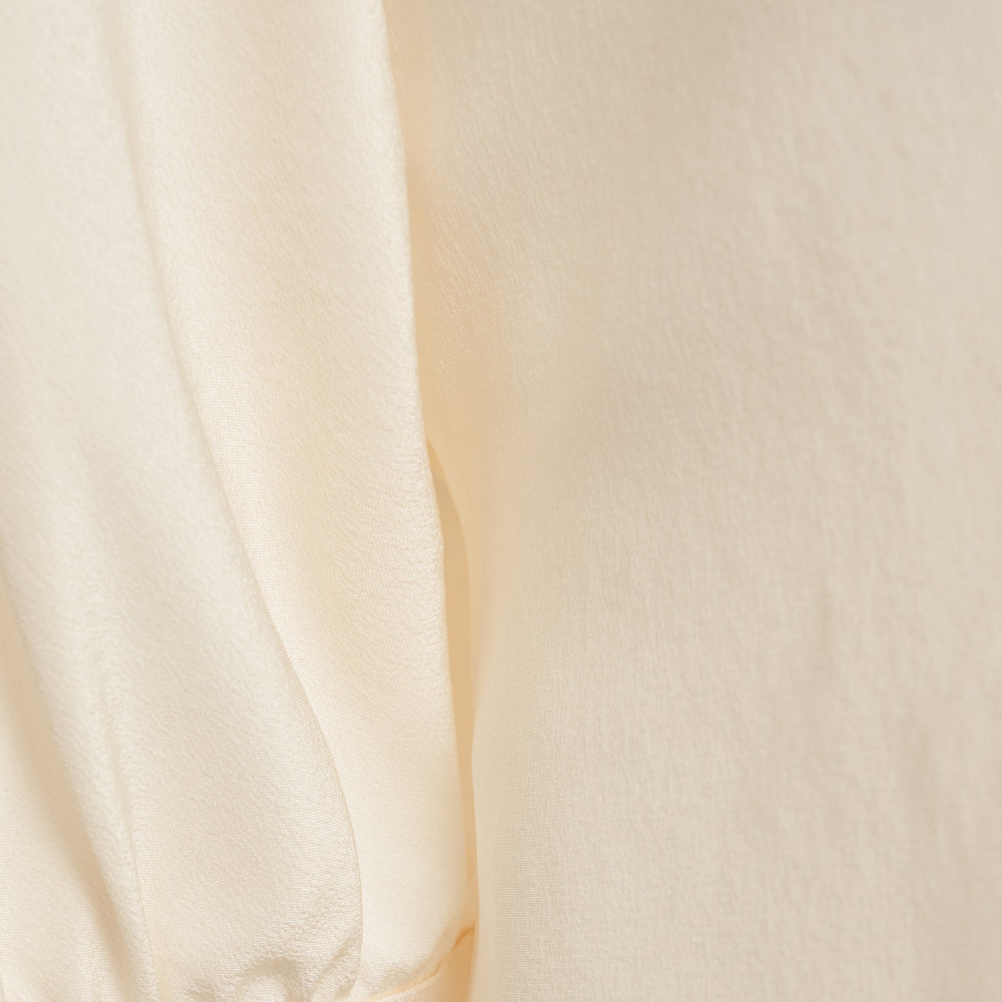 Cream silk crêpe de chine blouse with a short puff sleeves and a front button closure.