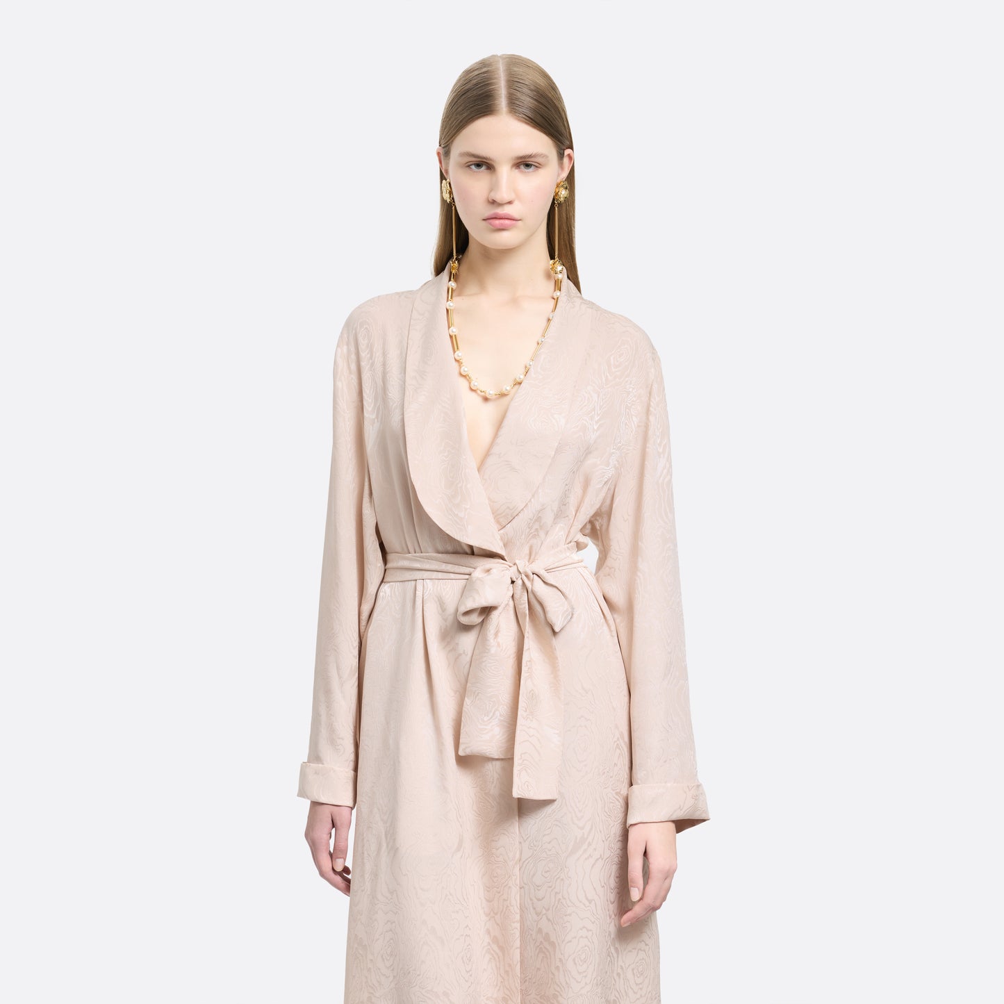 Blush silk moiré robe cut to a fluid silhouette with a shawl collar and long sleeves. Finished with a self-tie belt at the waist.