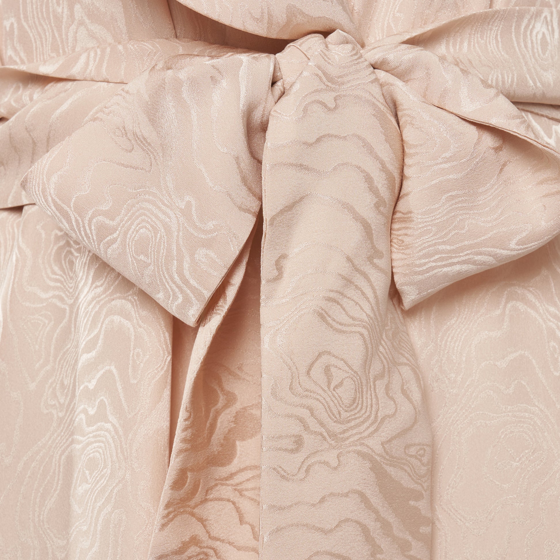 Blush silk moiré robe cut to a fluid silhouette with a shawl collar and long sleeves. Finished with a self-tie belt at the waist.