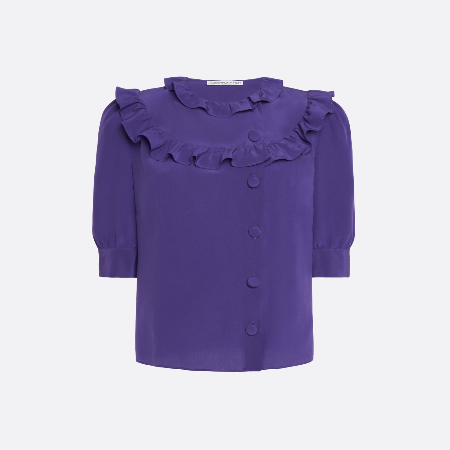 Purple silk crêpe de chine blouse with ruffle trims, short puff sleeves and a side button closure.

Look 7 – Fall Winter 2026 Lookbook.