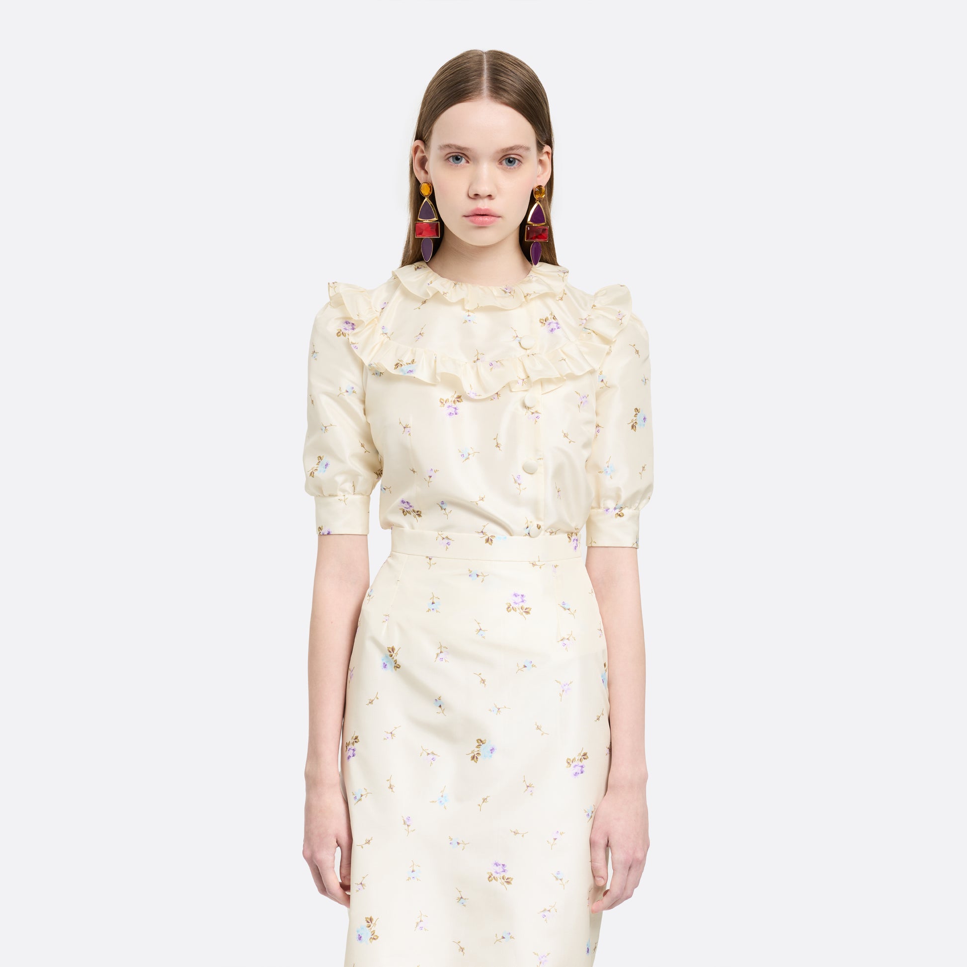 Floral-print white silk taffeta blouse with ruffle trims, short puff sleeves and a side button closure.