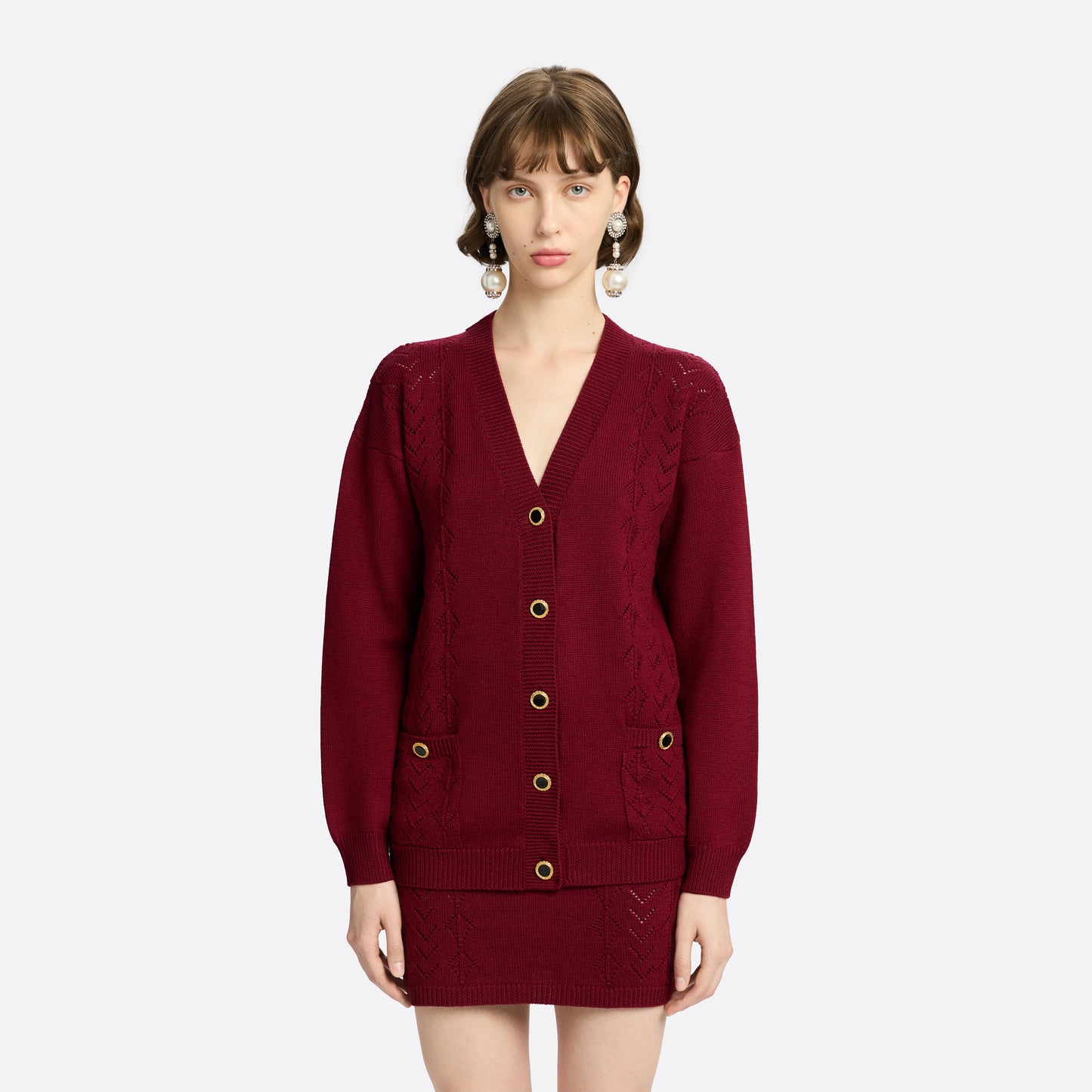 Bordeaux merino wool lace-knit cardigan cut to a relaxed silhouette with a V-neckline. Finished with patch pockets and black and gold-tone buttons.