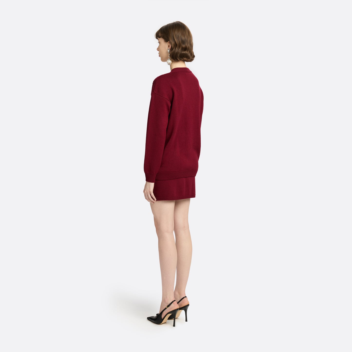 Bordeaux merino wool lace-knit cardigan cut to a relaxed silhouette with a V-neckline. Finished with patch pockets and black and gold-tone buttons.