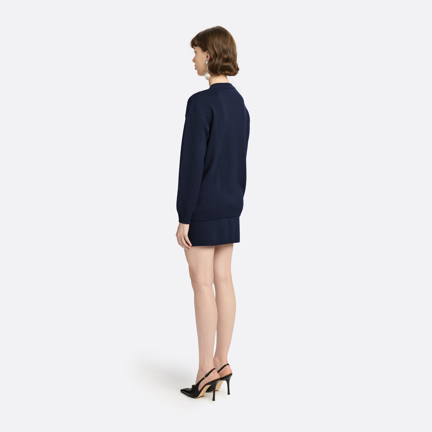 Navy merino wool lace-knit cardigan cut to a relaxed silhouette with a V-neckline. Finished with patch pockets and black and gold-tone buttons.