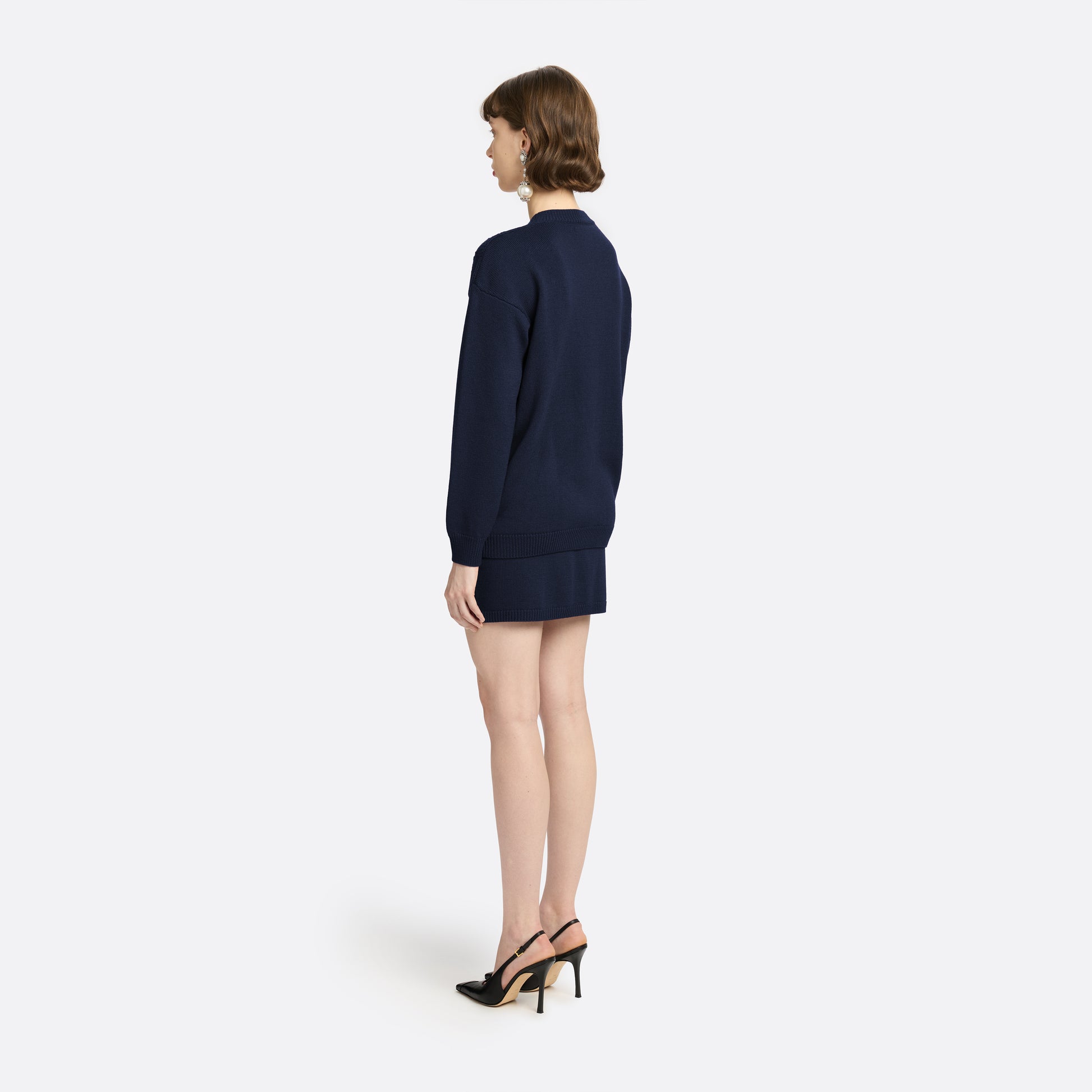 Navy merino wool lace-knit cardigan cut to a relaxed silhouette with a V-neckline. Finished with patch pockets and black and gold-tone buttons.