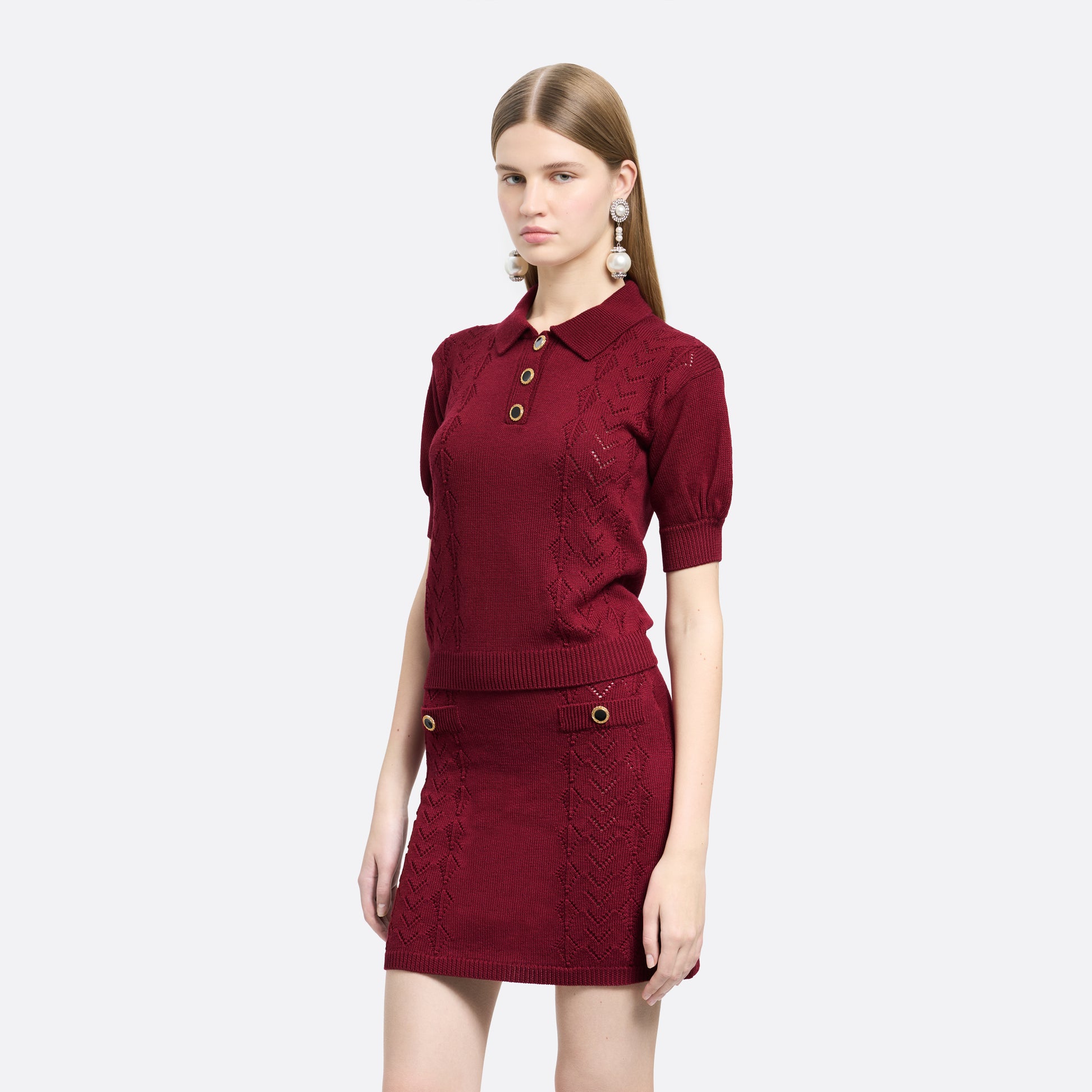 Bordeaux merino wool lace-knit polo cut to a fitted silhouette with short puff sleeves and black and gold-tone buttons.