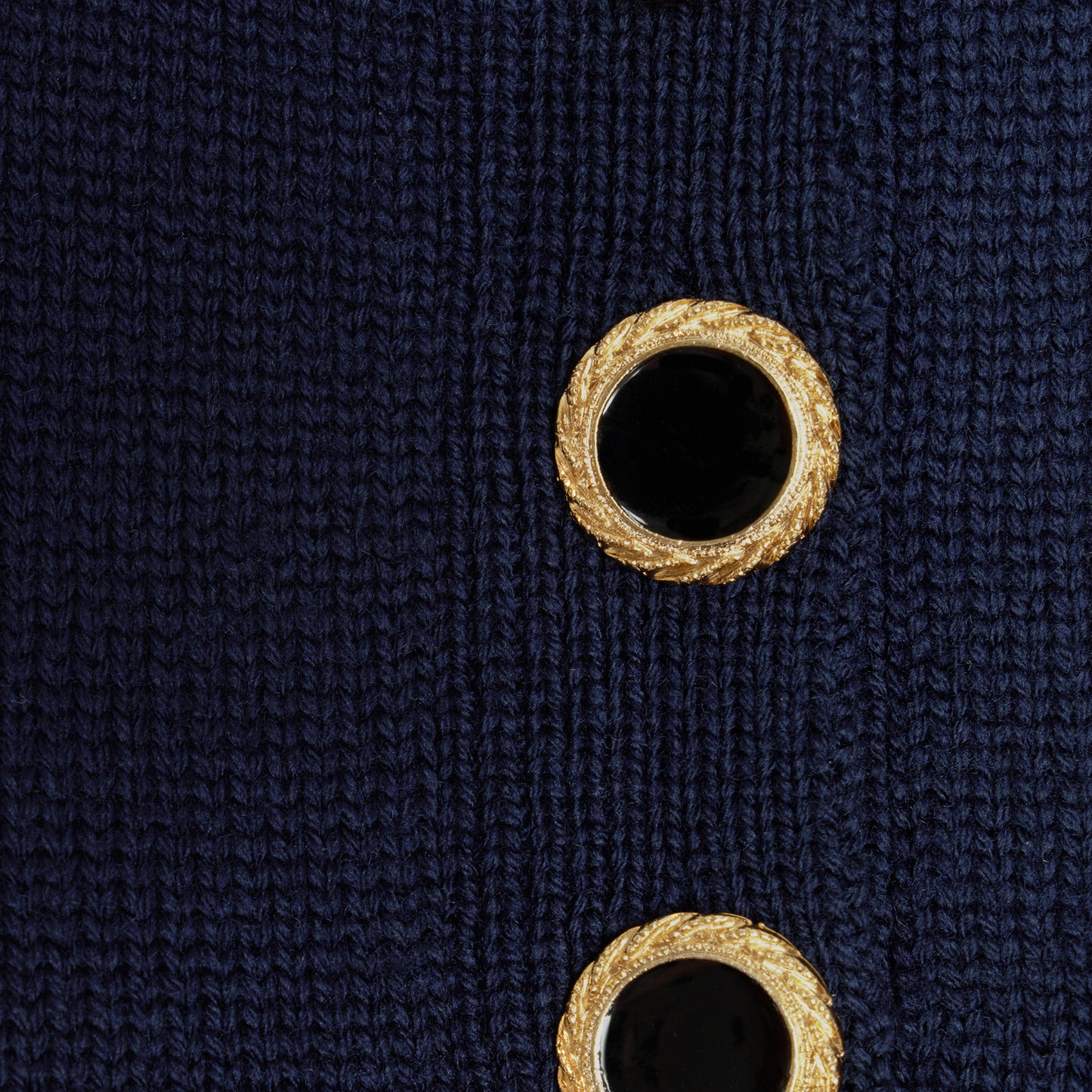Navy blue merino wool lace-knit polo cut to a fitted silhouette with short puff sleeves and black and gold-tone buttons.