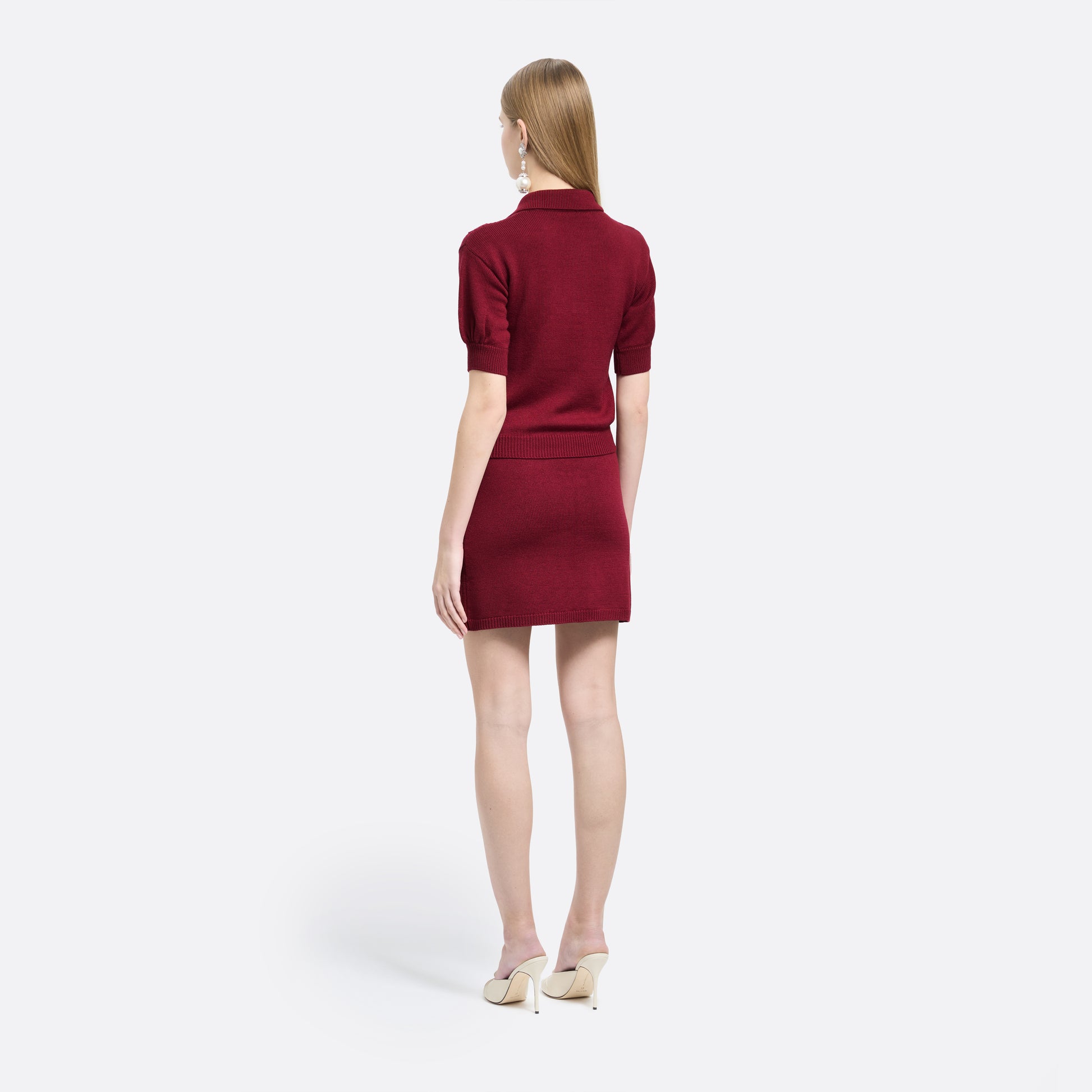 Bordeaux merino wool lace-knit mini skirt cut to a fitted silhouette with pocket details and black and gold-tone buttons.
