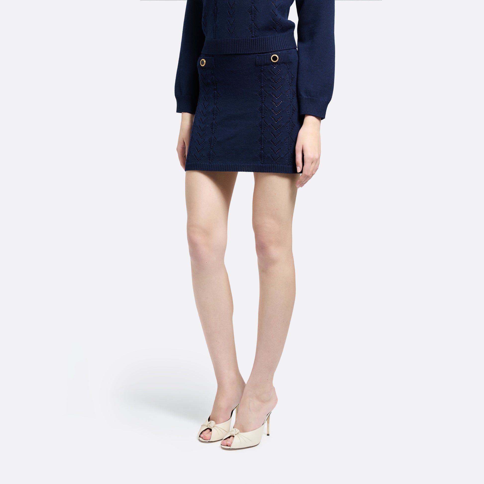 Navy-blue merino wool lace-knit mini skirt cut to a fitted silhouette with pocket details and black and gold-tone buttons.