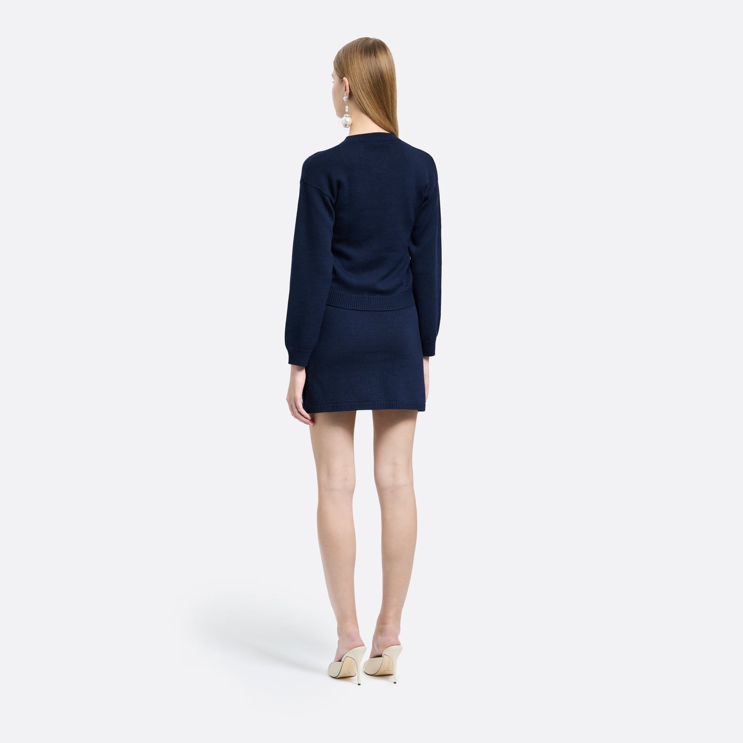Navy-blue merino wool lace-knit mini skirt cut to a fitted silhouette with pocket details and black and gold-tone buttons.