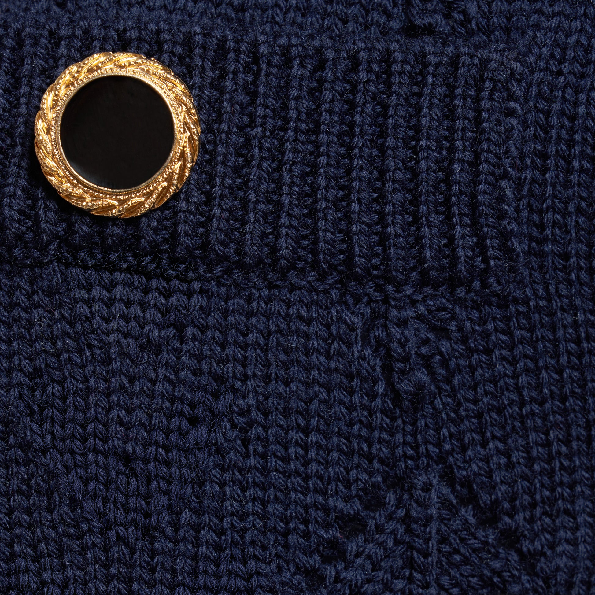 Navy-blue merino wool lace-knit mini skirt cut to a fitted silhouette with pocket details and black and gold-tone buttons.