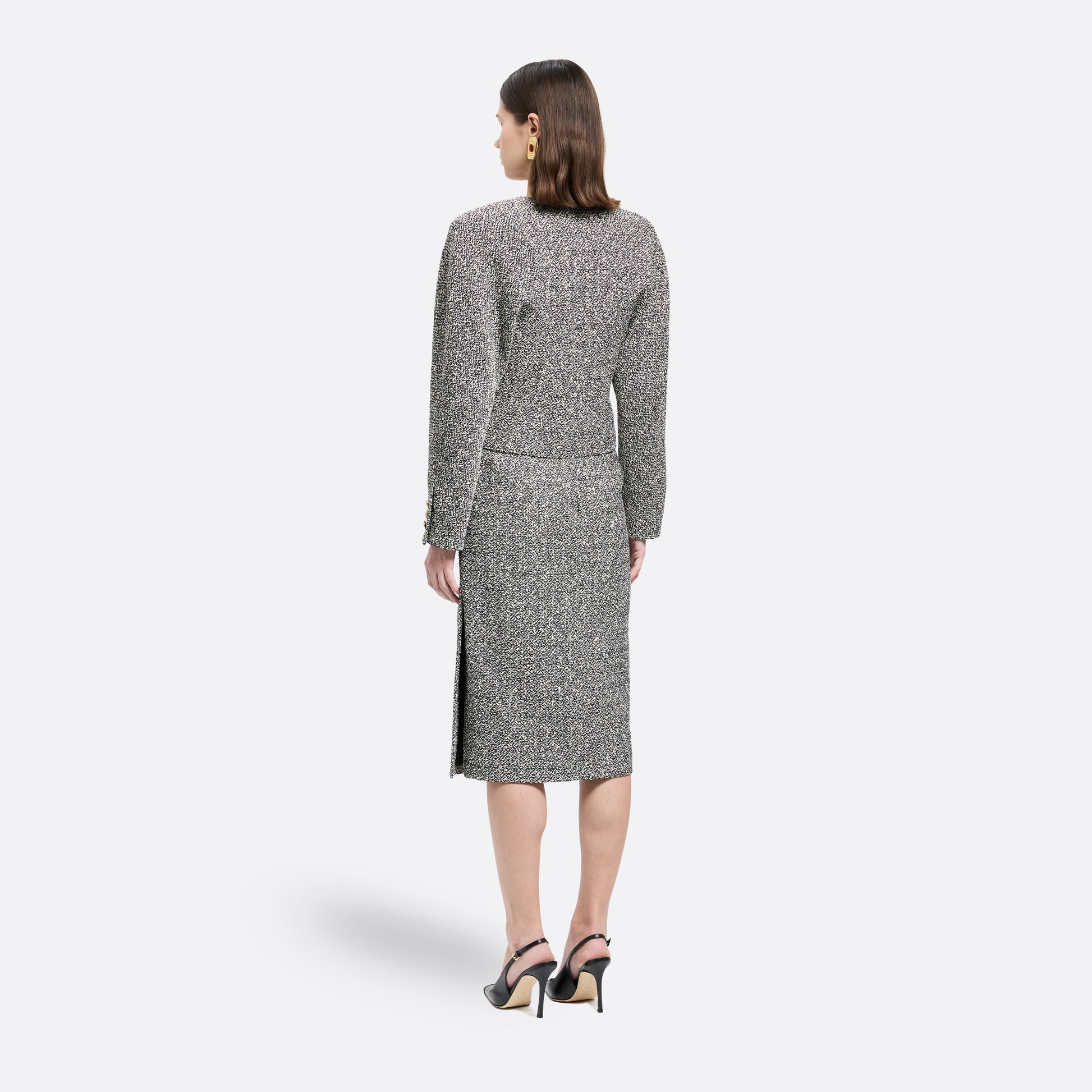 Black and white melange sequin tweed jacket cut in a cropped, boxy silhouette with defined shoulders and finished with black and gold-tone buttons.