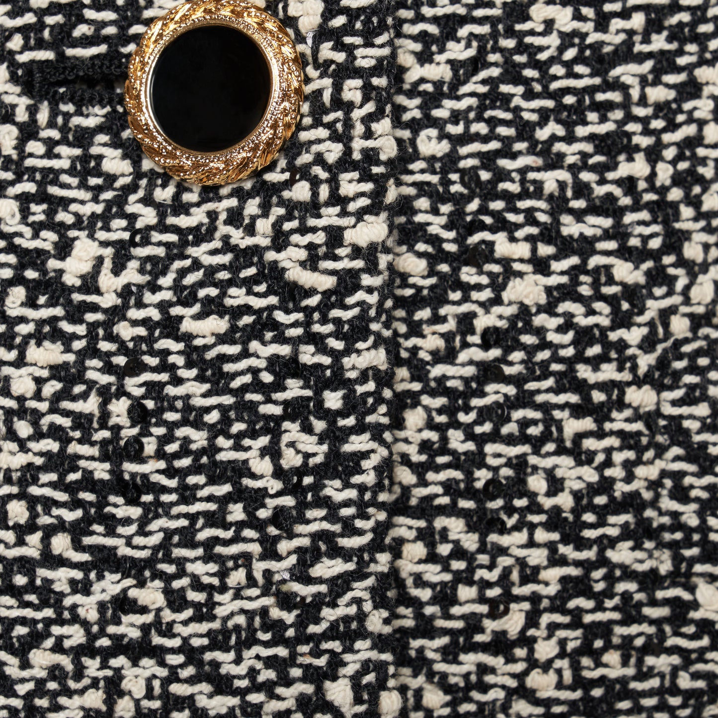 Black and white melange sequin tweed jacket cut in a cropped, boxy silhouette with defined shoulders and finished with black and gold-tone buttons.