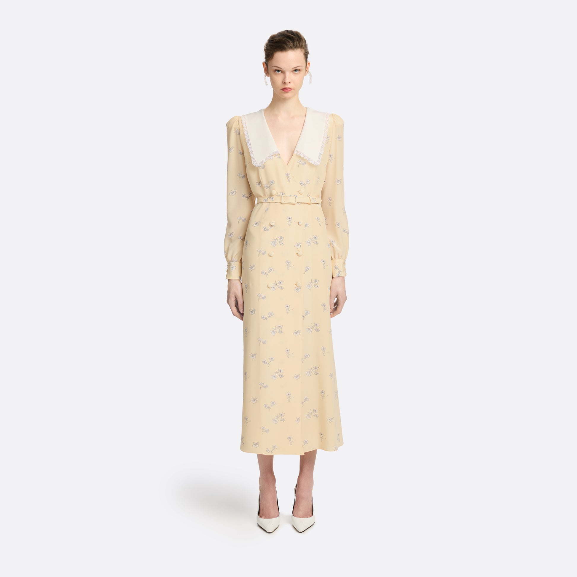 Pale yellow floral print silk crêpe de chine double-breasted midi dress with long sleeves, featuring a white lace-trimmed collar and belt.