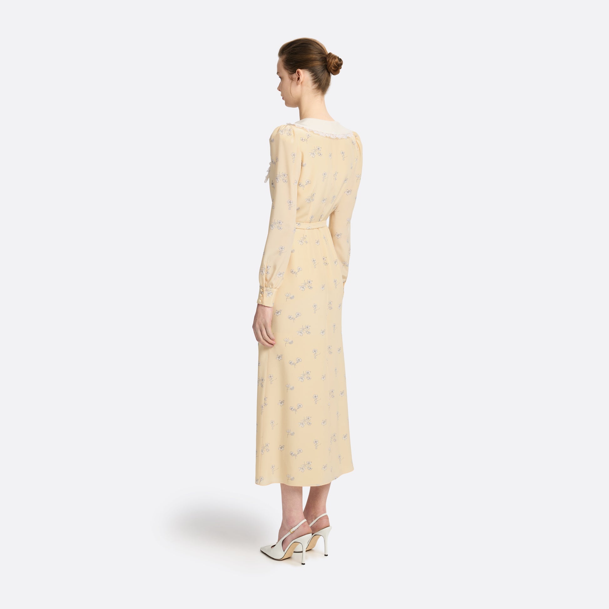 Pale yellow floral print silk crêpe de chine double-breasted midi dress with long sleeves, featuring a white lace-trimmed collar and belt.