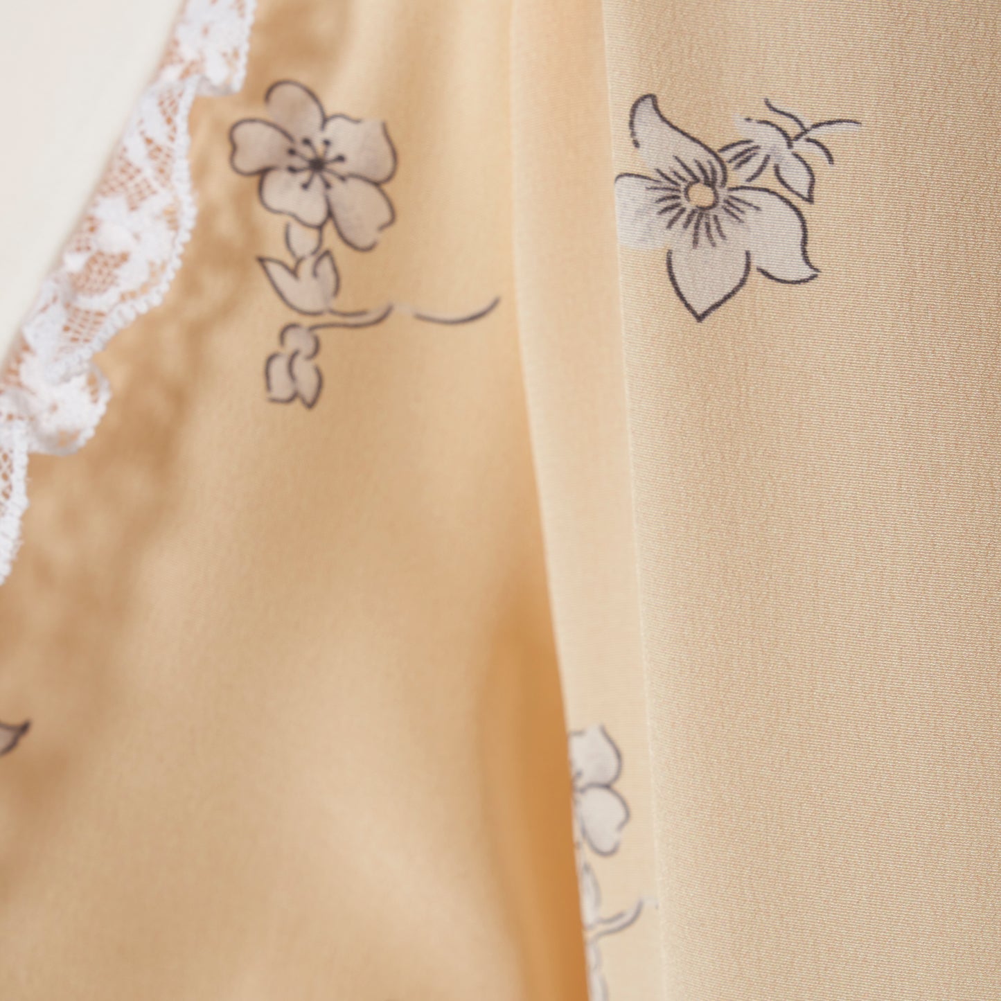 Pale yellow floral print silk crêpe de chine double-breasted midi dress with long sleeves, featuring a white lace-trimmed collar and belt.
