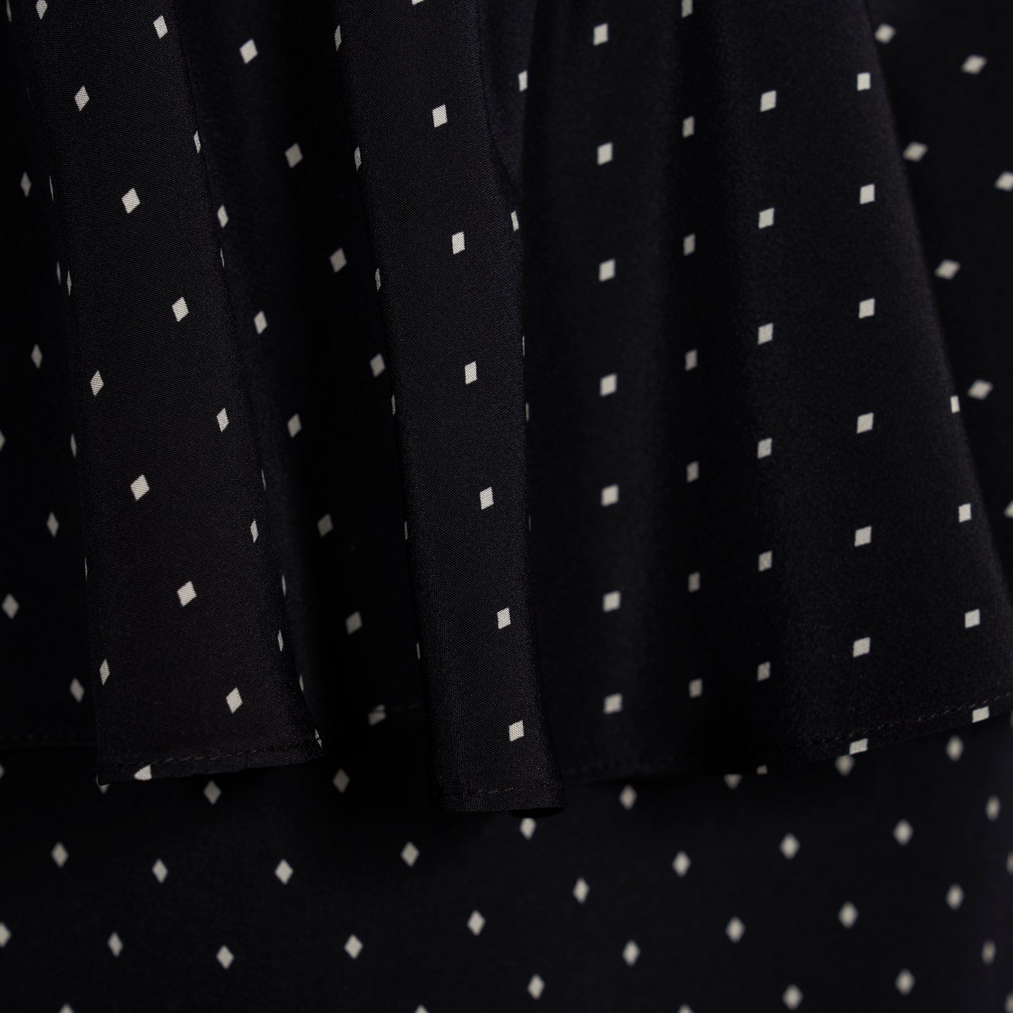 Ivory diamond print on black silk crêpe de chine midi dress with puff sleeves and pencil skirt, featuring a peplum waist and a bow.
