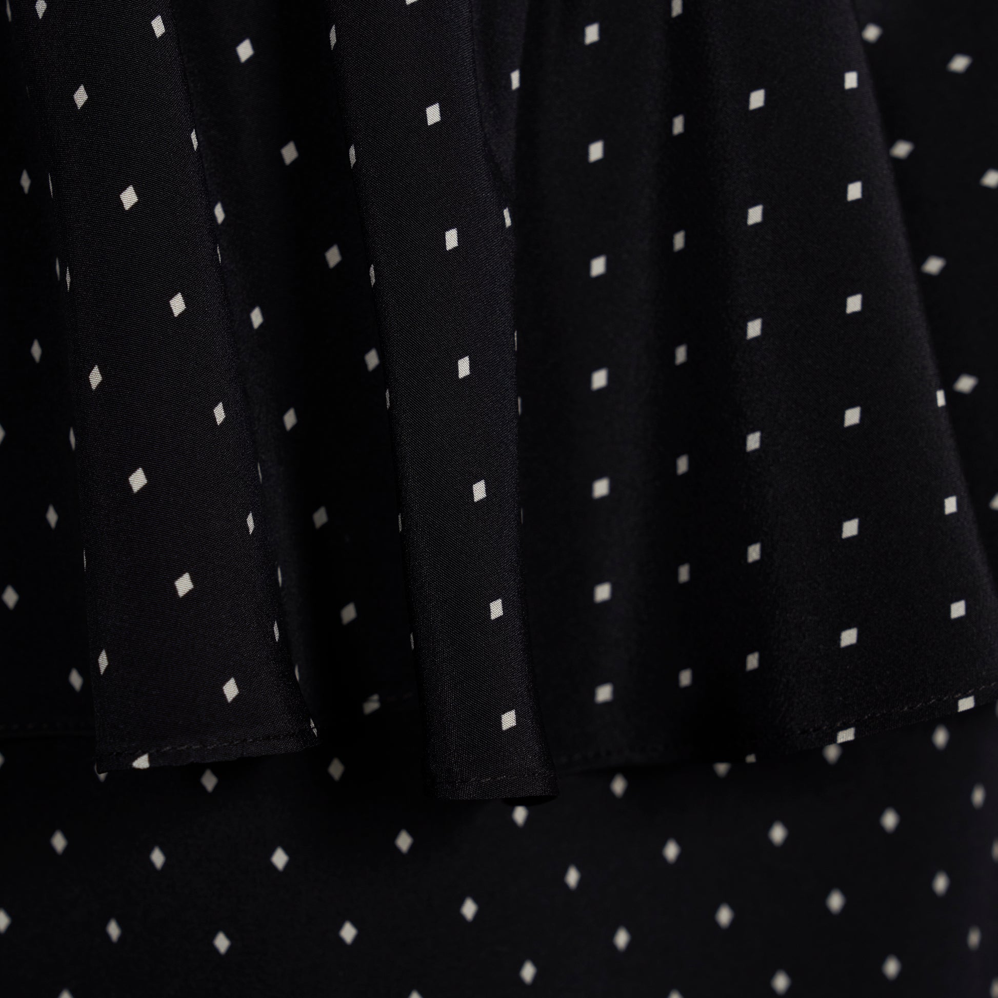 Ivory diamond print on black silk crêpe de chine midi dress with puff sleeves and pencil skirt, featuring a peplum waist and a bow.