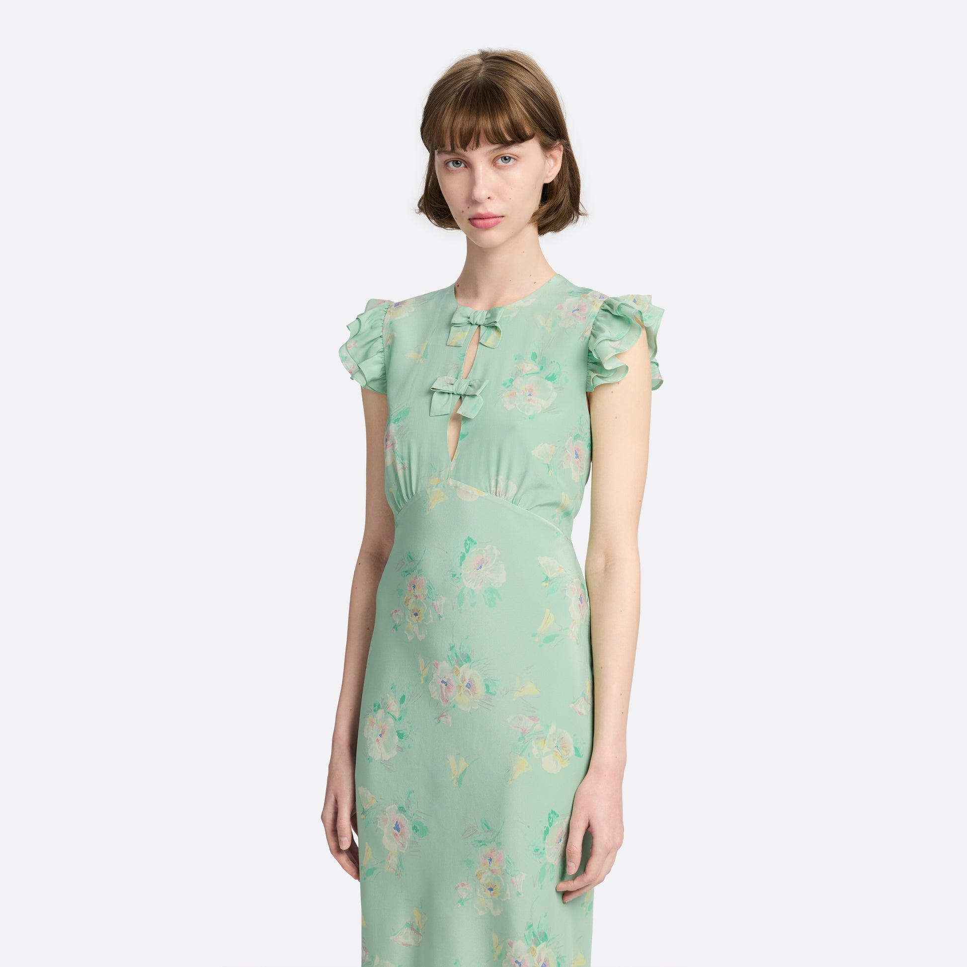 Light green floral print silk crêpe de chine sleeveless midi dress with bows, featuring keyhole cut-out and ruffled details.