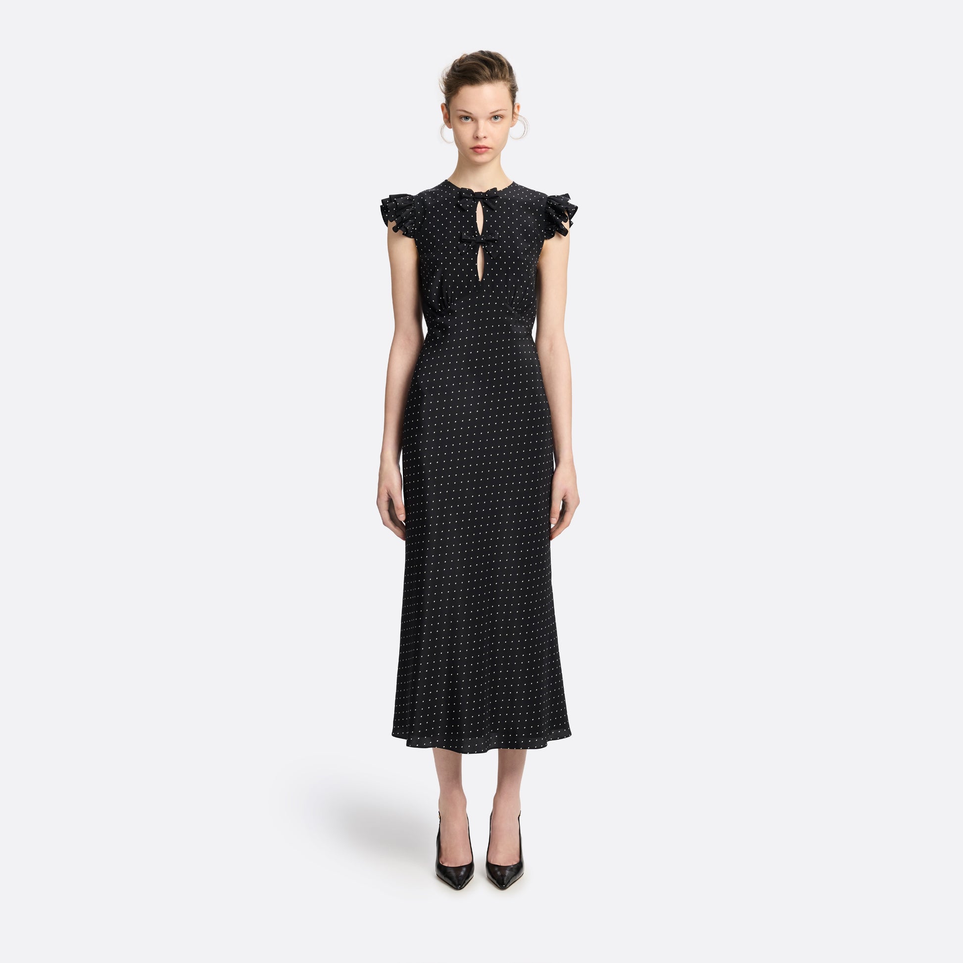 Ivory diamond print on black silk crêpe de chine sleeveless midi dress with bows, featuring keyhole cut-out and ruffled details.