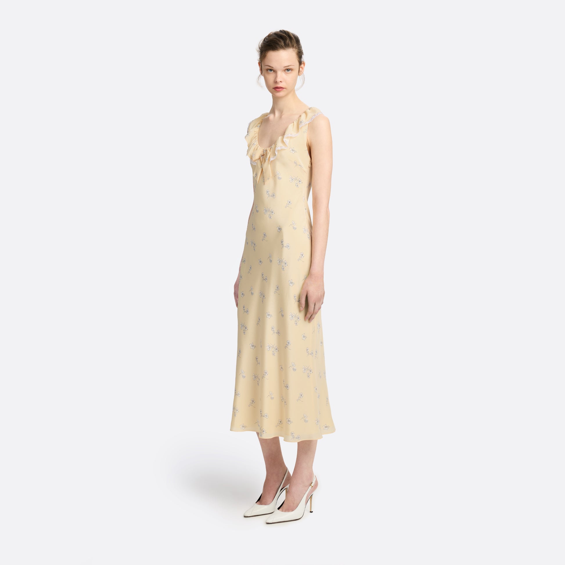 Pale yellow floral print silk crêpe de chine slip midi dress with a scoop neckline, featuring ruffles, lace trim, and a bow.
