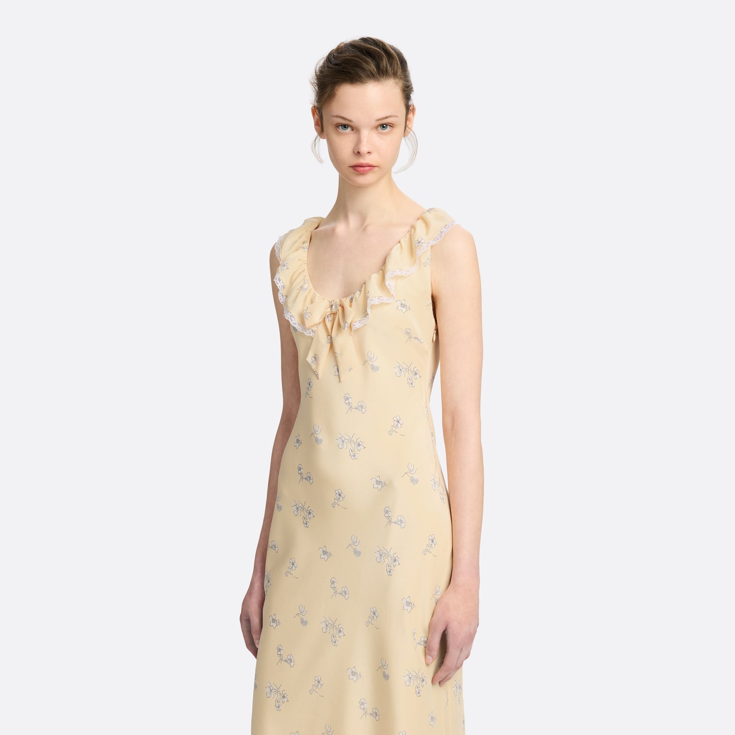 Pale yellow floral print silk crêpe de chine slip midi dress with a scoop neckline, featuring ruffles, lace trim, and a bow.