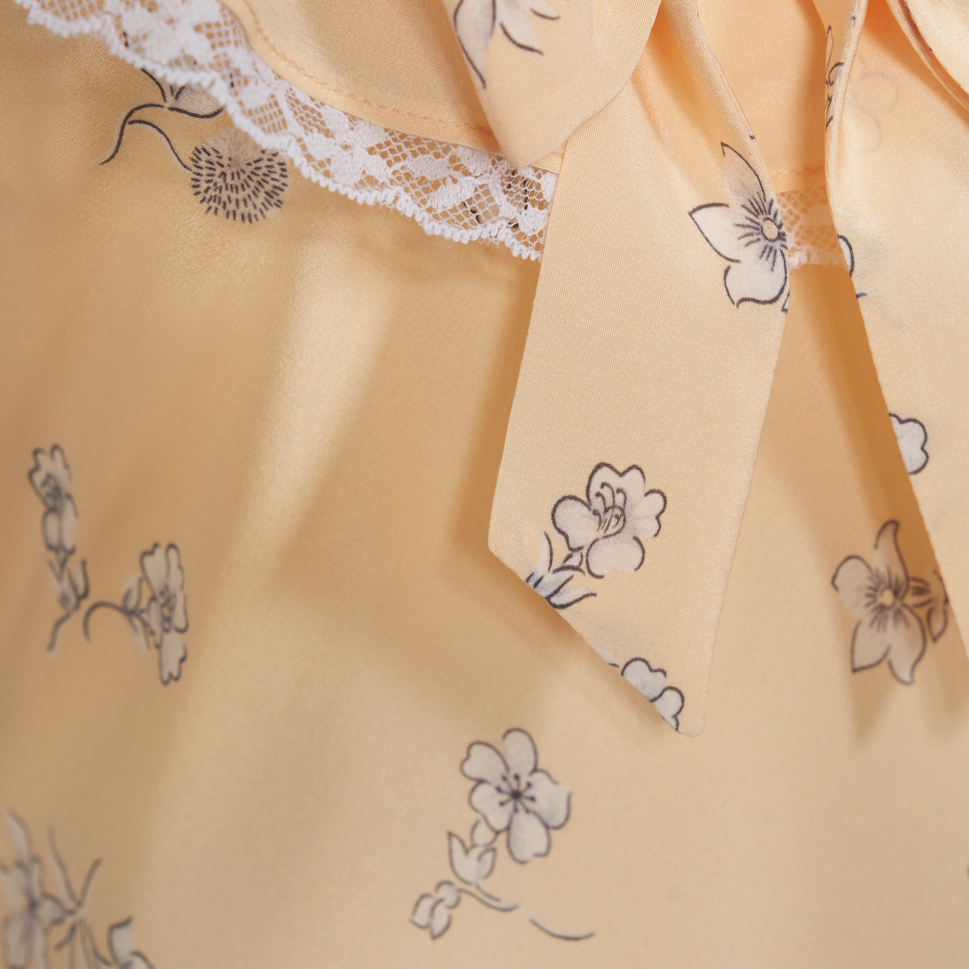 Pale yellow floral print silk crêpe de chine slip midi dress with a scoop neckline, featuring ruffles, lace trim, and a bow.