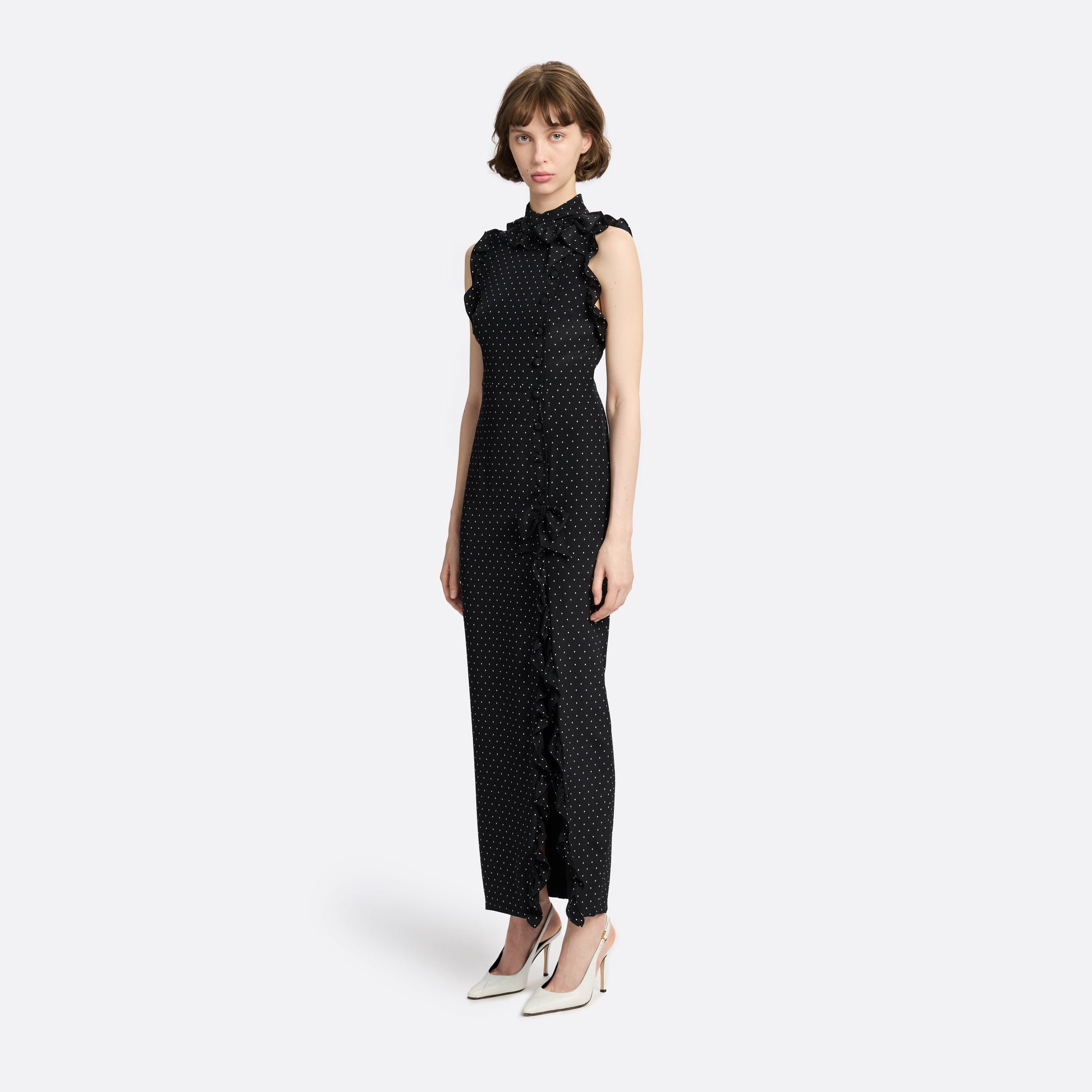 Ivory diamond print on black silk crêpe de chine sleeveless midi dress with a high ruffled neckline, featuring button detail, side split and bow.